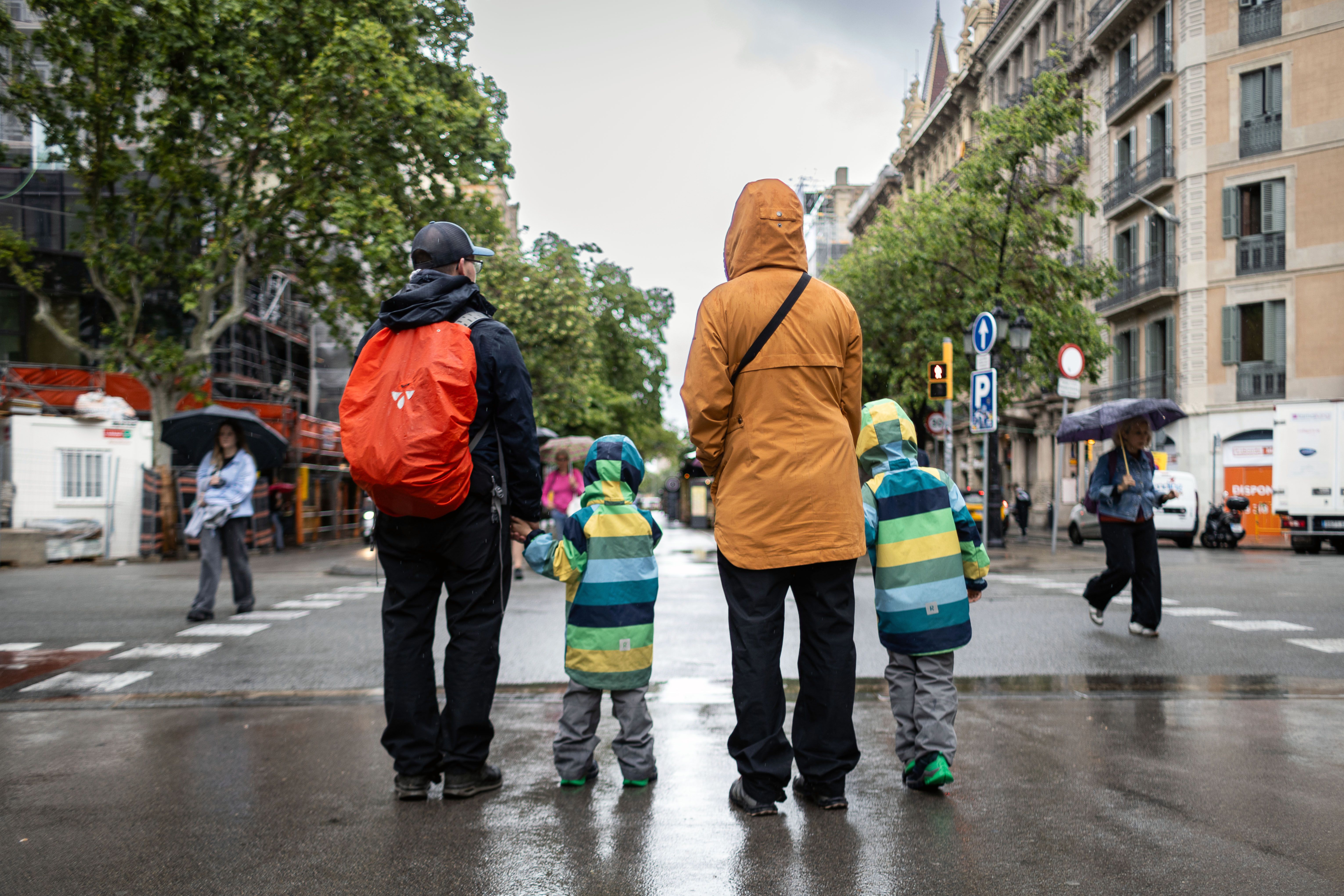 Una família sota la pluja en el centre de Barcelona