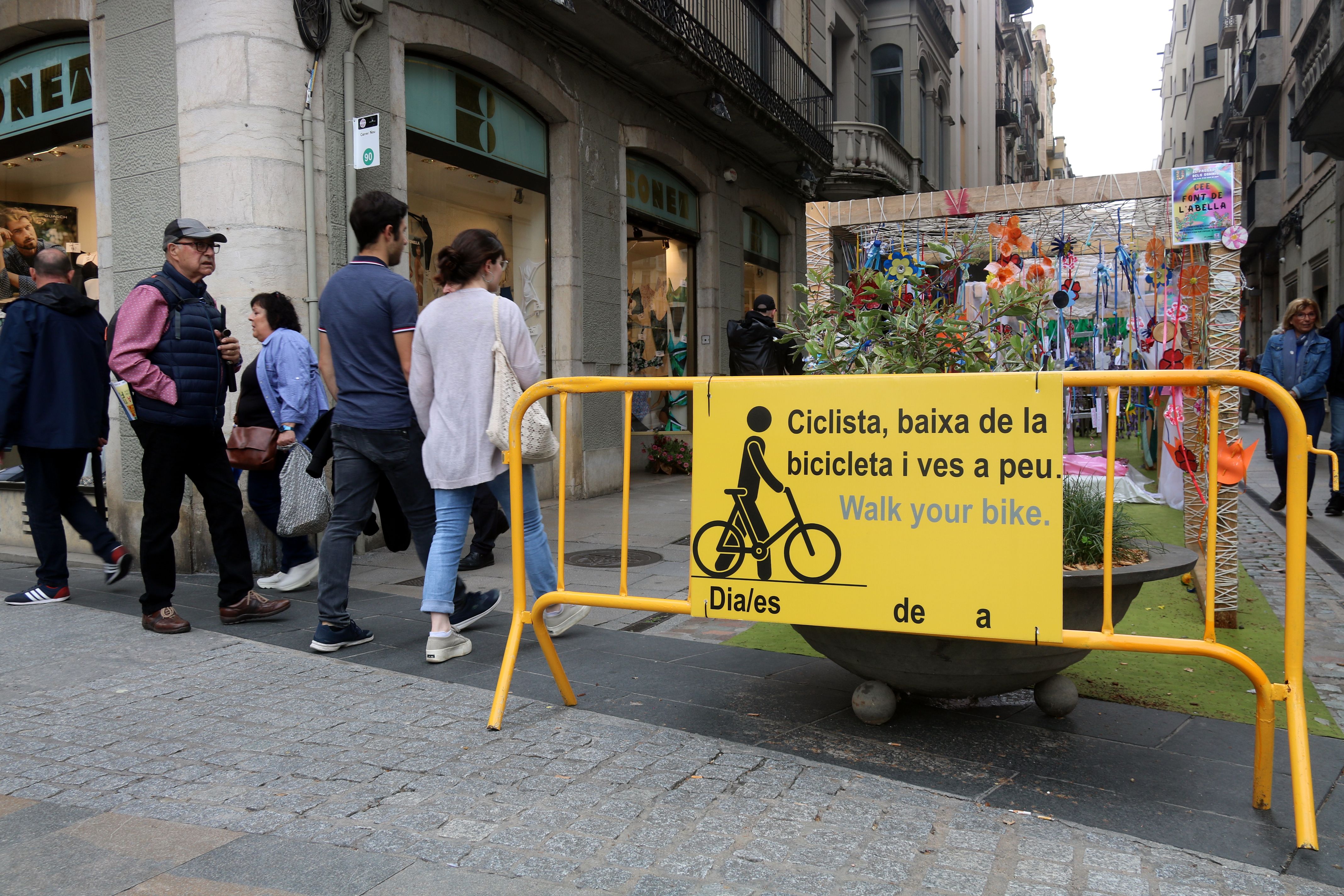 Cartell de l'Ajuntament de Girona que demana als ciclistes que vagin a peu 