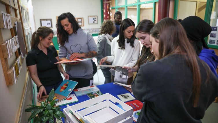 Les famílies escollint llibres a l'escola bressol de Sant Miquel d'Olot
