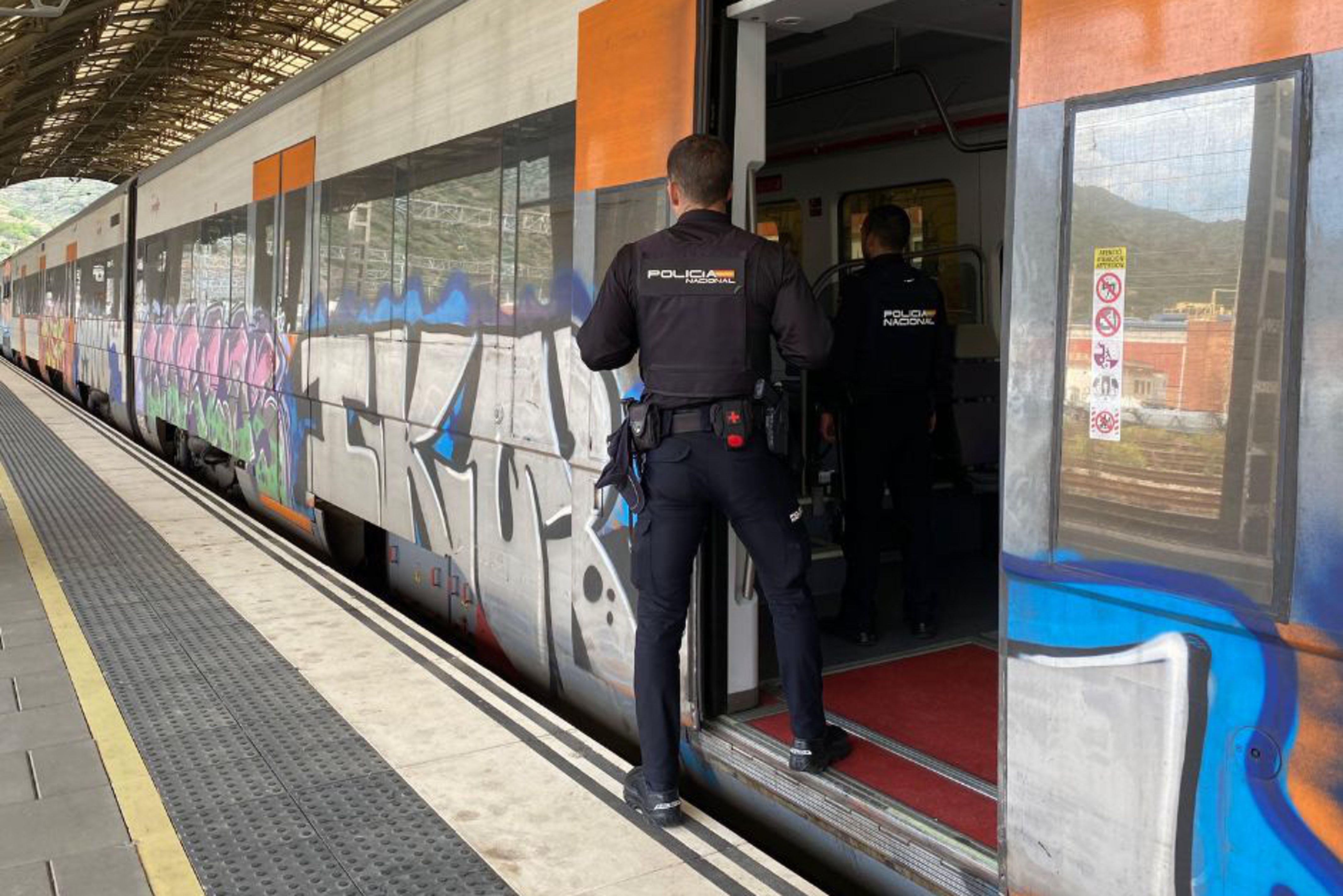 Dos agents de la Policia Nacional pugen en un vagó de tren aturat a l'estació de Portbou per controlar la sortida i entrada de persones a l'Estat