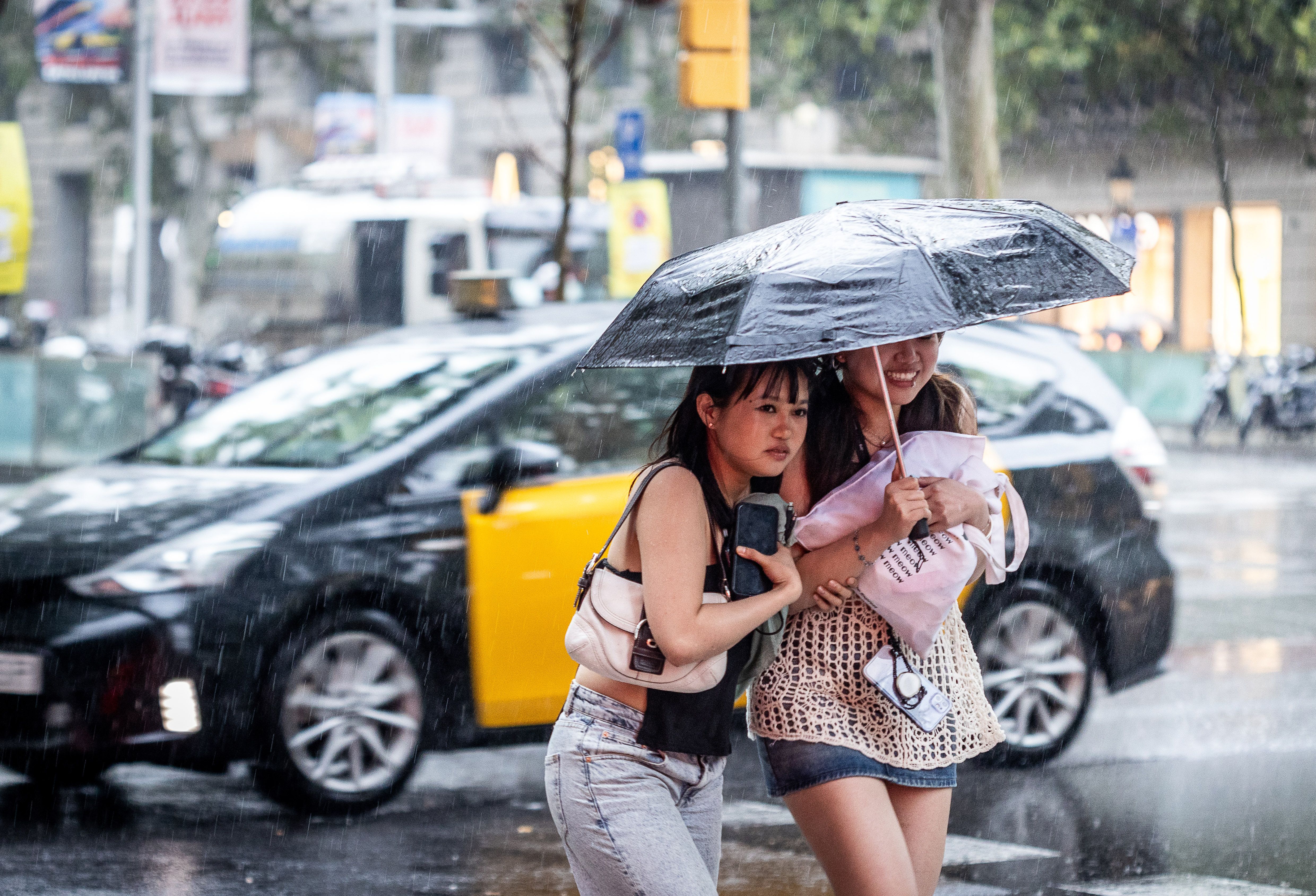 Persones es protegeixen de la pluja al centre de Barcelona