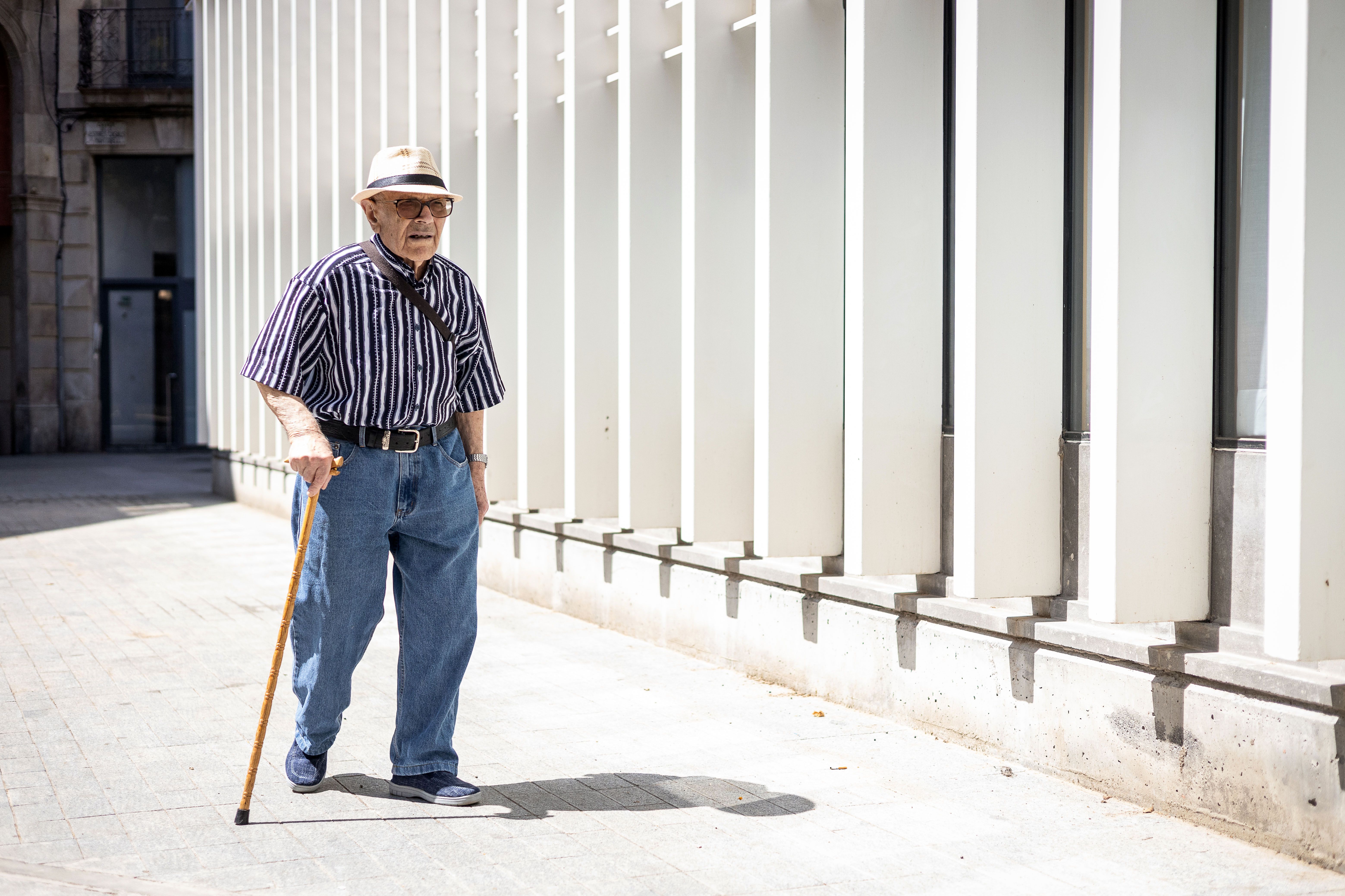 Un pensionista camina pel centre de Barcelona