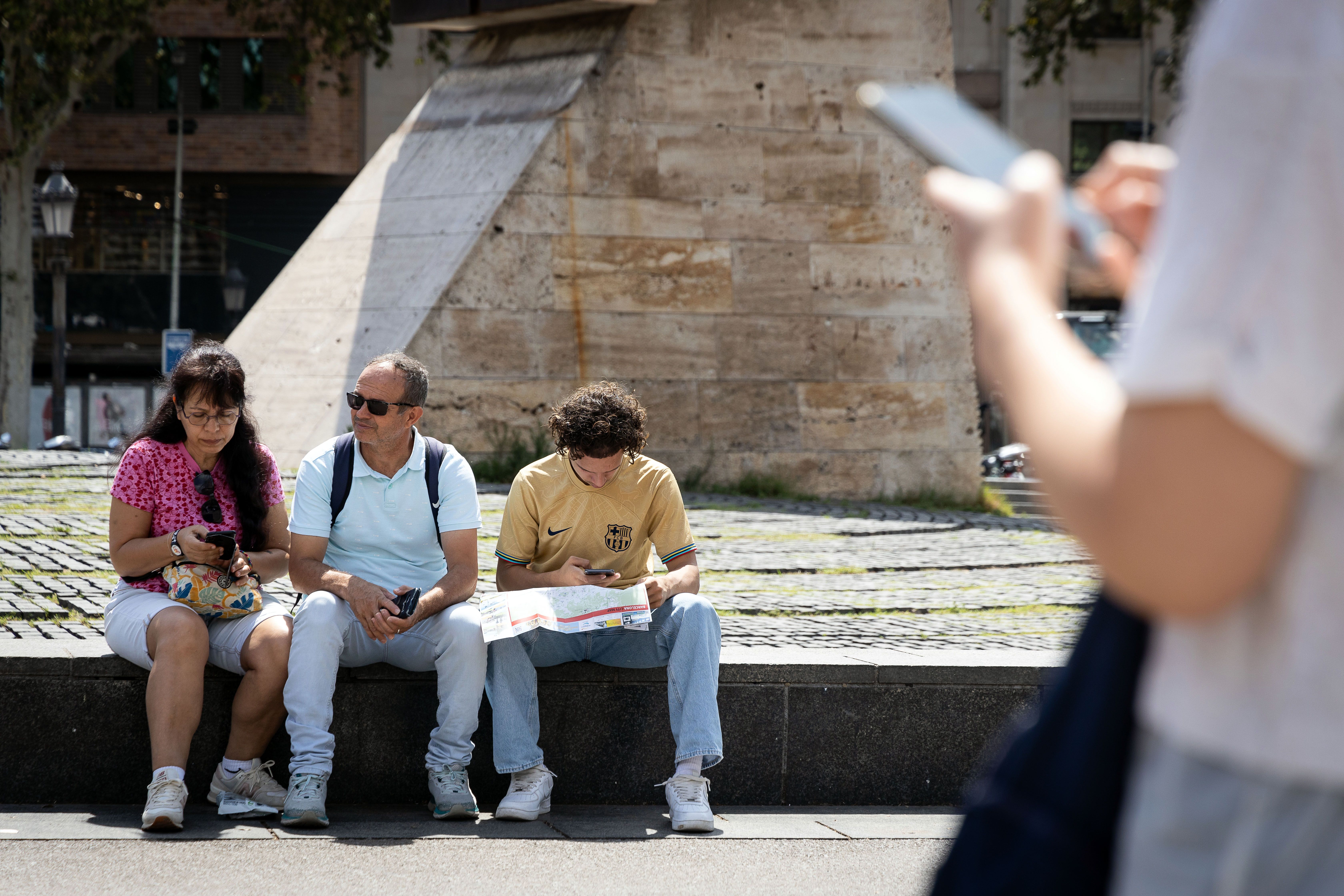 Un grup de turistes consulta un mapa a la plaça Catalunya