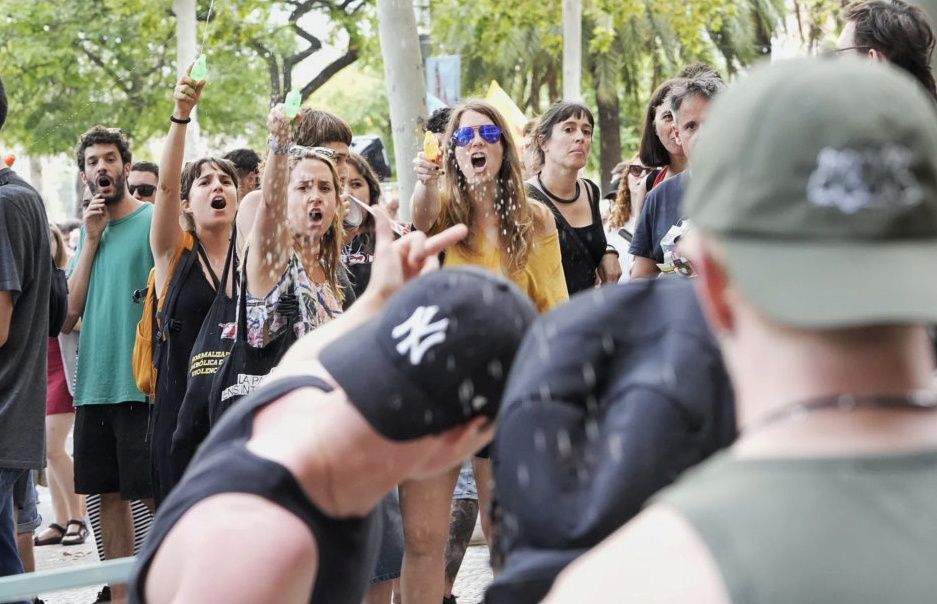 Alguns dels manifestants ruixen amb pistoles d'aigua un estol de turistes