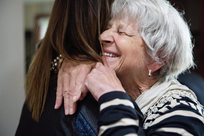 Una àvia abraça la seva neta