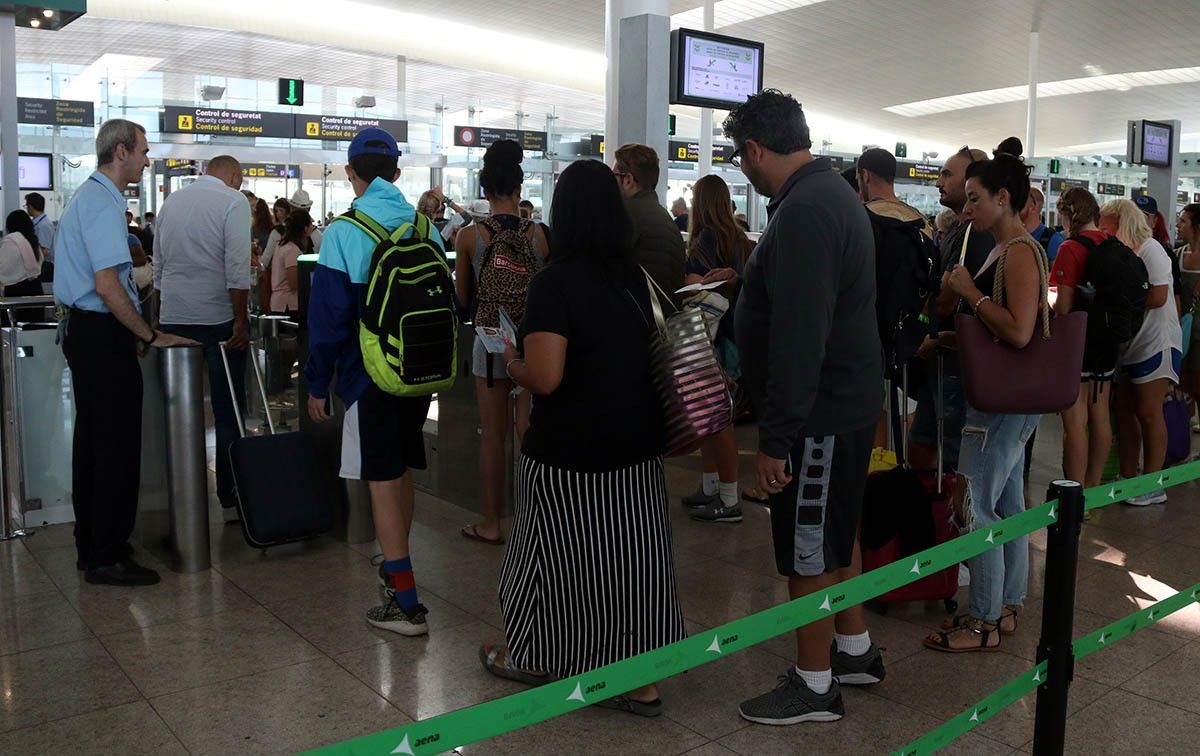 Passatgers esperant per passar el control de seguretat a l'aeroport del Prat