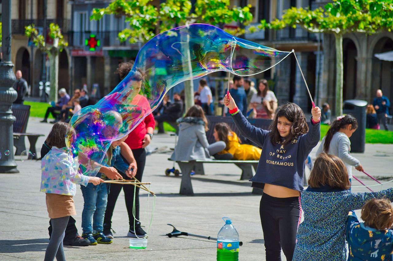 Un grup de nens jugant amb bombolles gegants al carrer