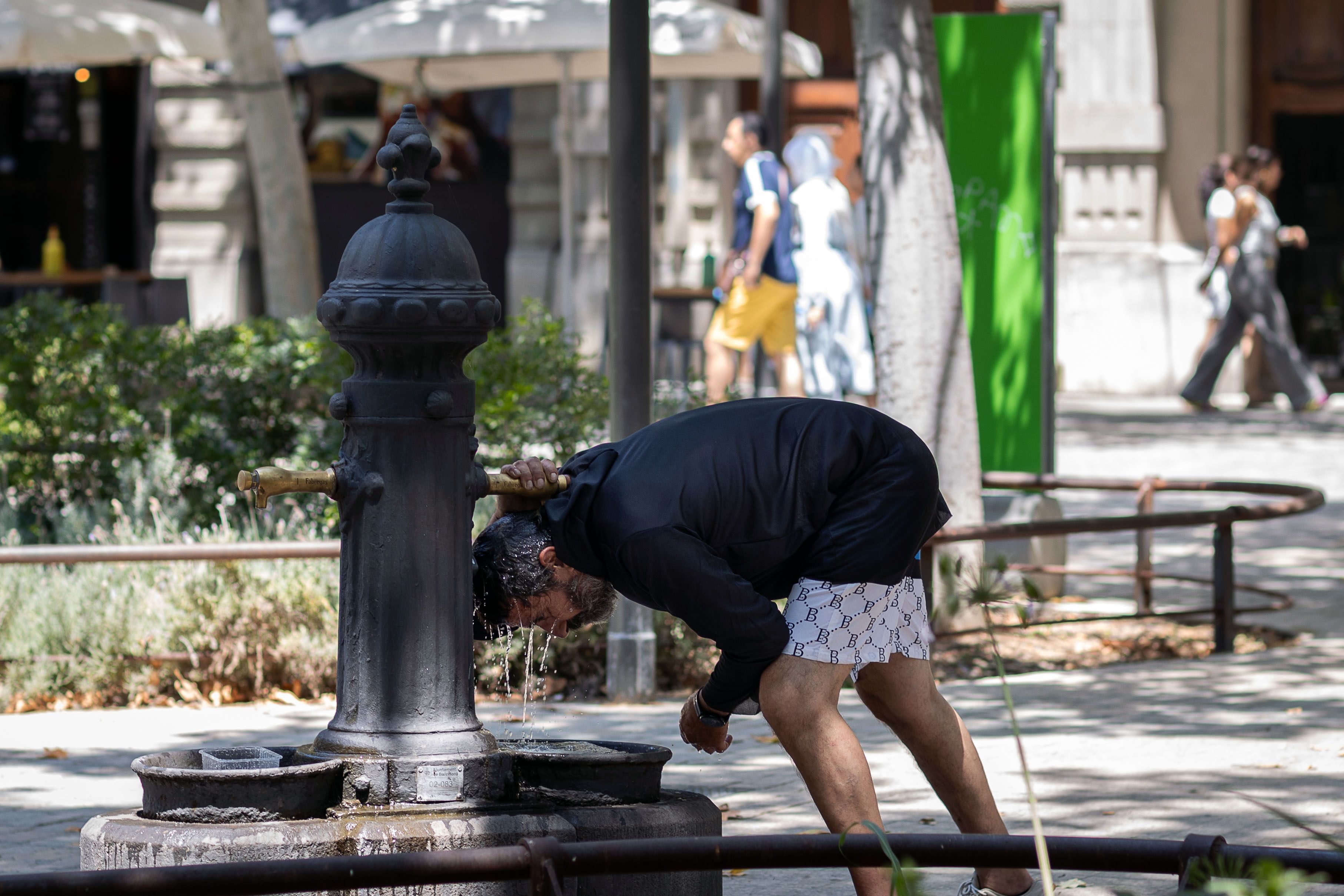 Un home es protegeix de la calor a Barcelona