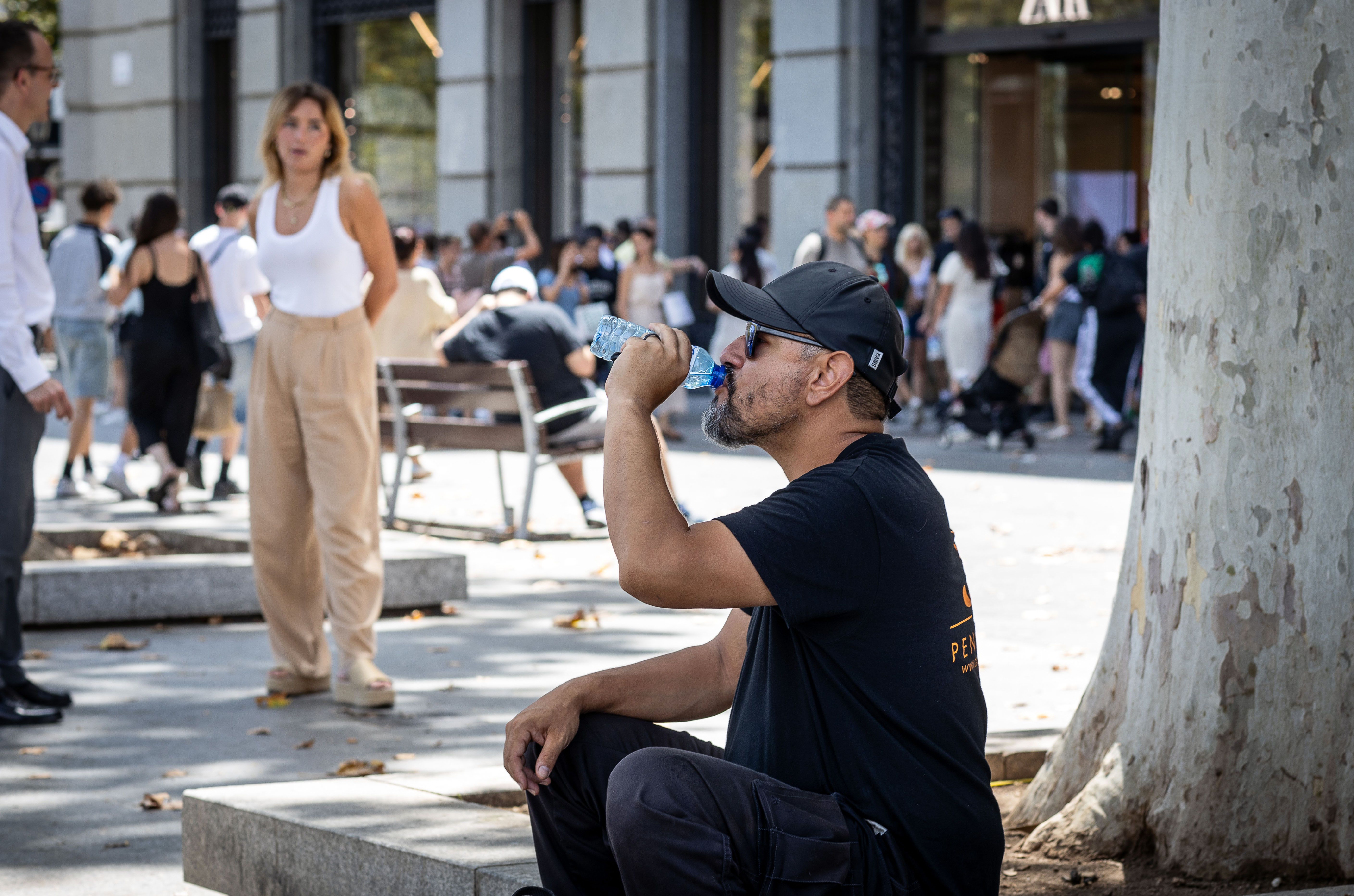Una persona beu aigua en ple pic de calor al centre de Barcelona