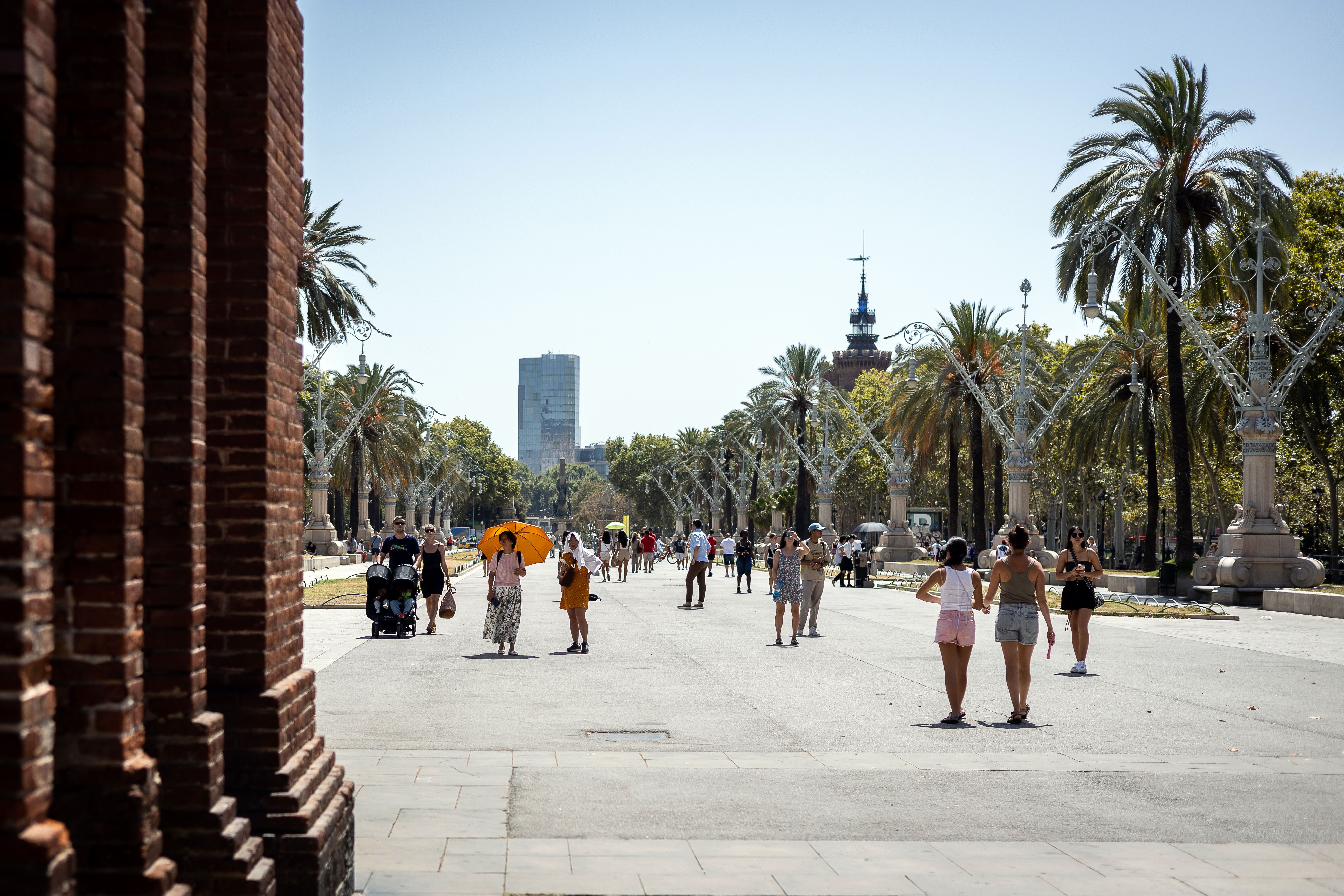 Uns turistes s'amaguen del sol al Passeig Lluís Companys de Barcelona