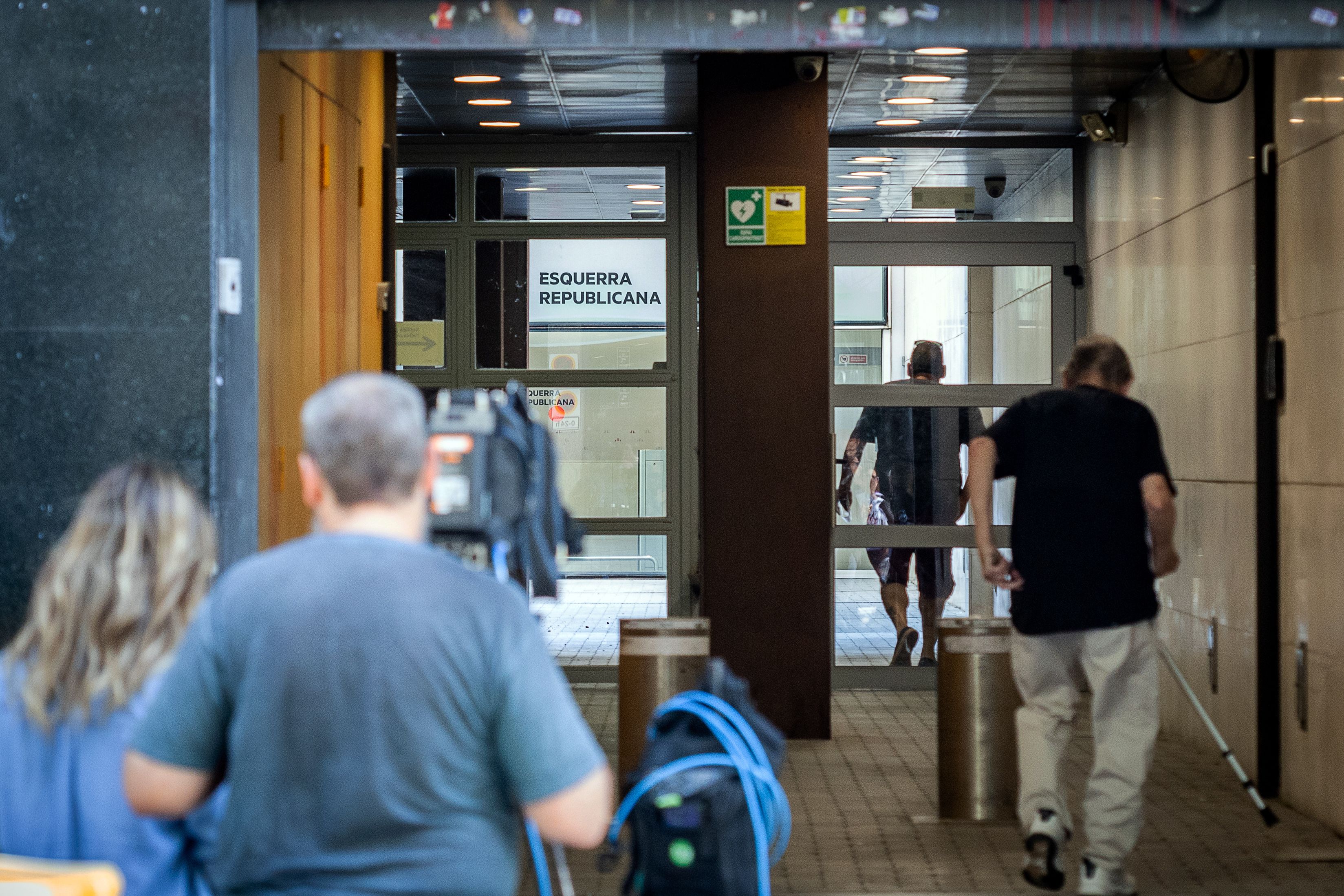 Militants d'ERC entren a la seu per votar presencialment.