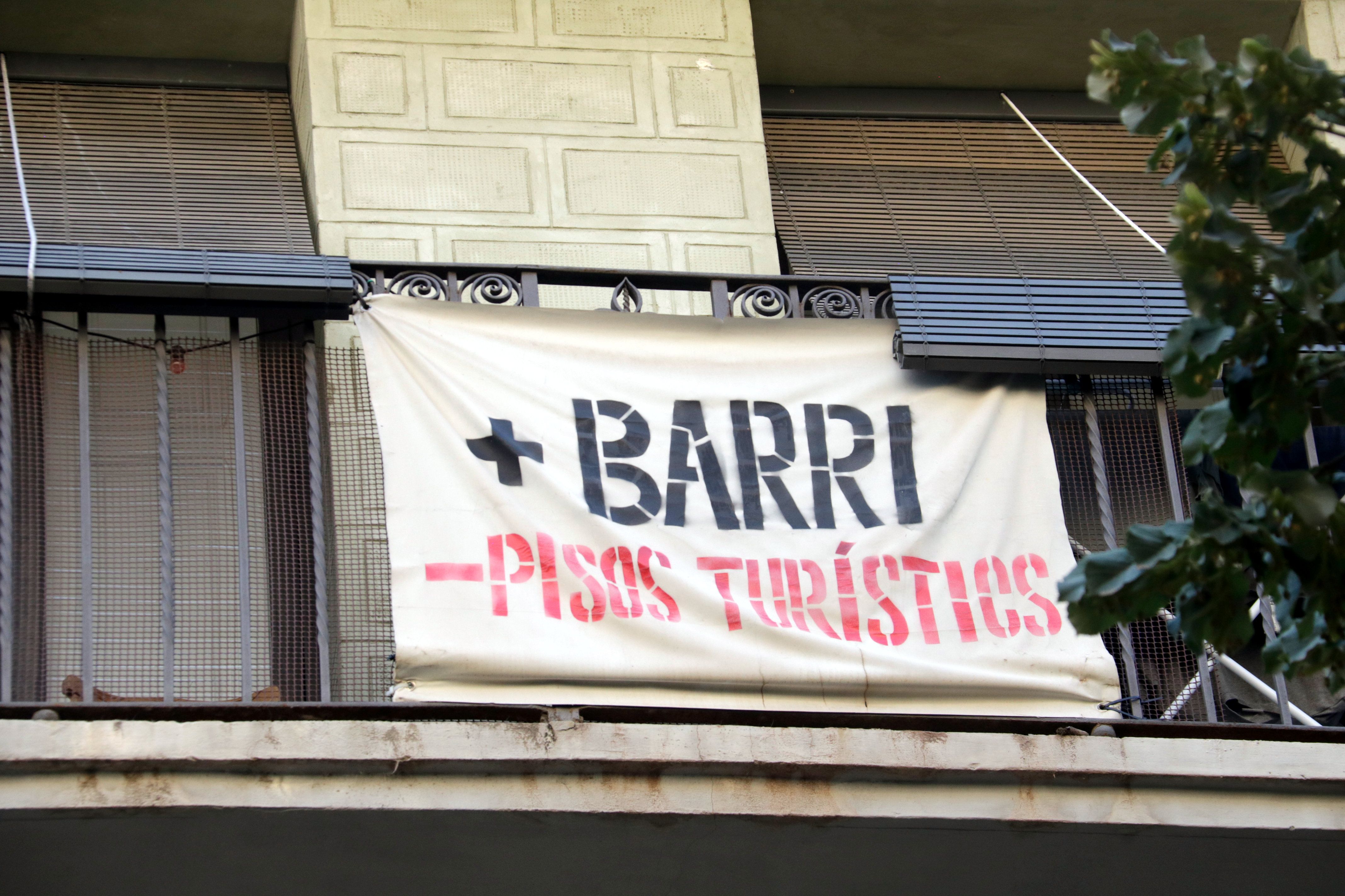 Una pancarta contra els pisos turístics en un balcó de Girona