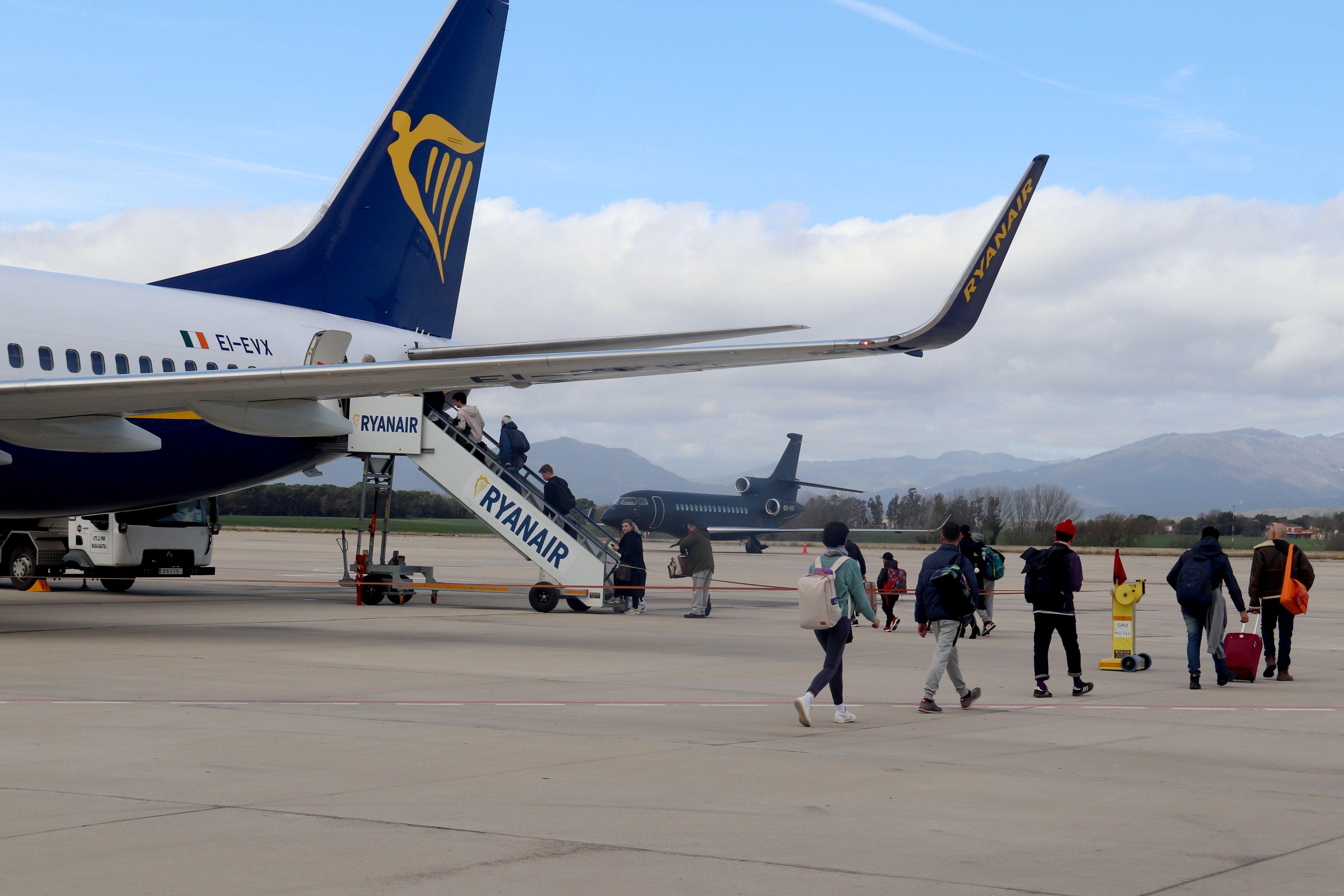 Els passatgers d'un vol de Girona per anar a Londres caminen cap a l'avió de Ryanair