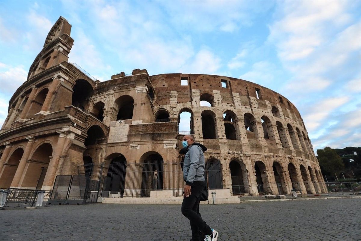 Una persona amb mascareta passeja davant del Colosseu de Roma
