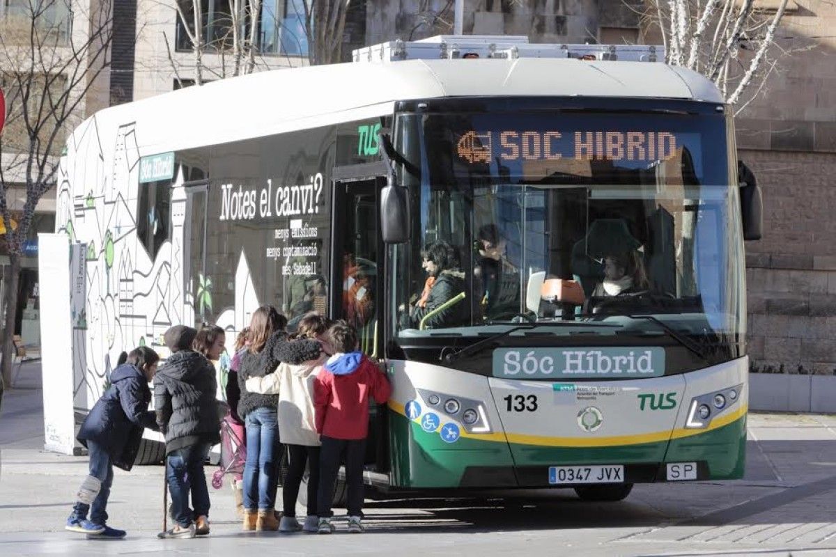 Un grup d'escolars visitant el nou autobús híbrid.