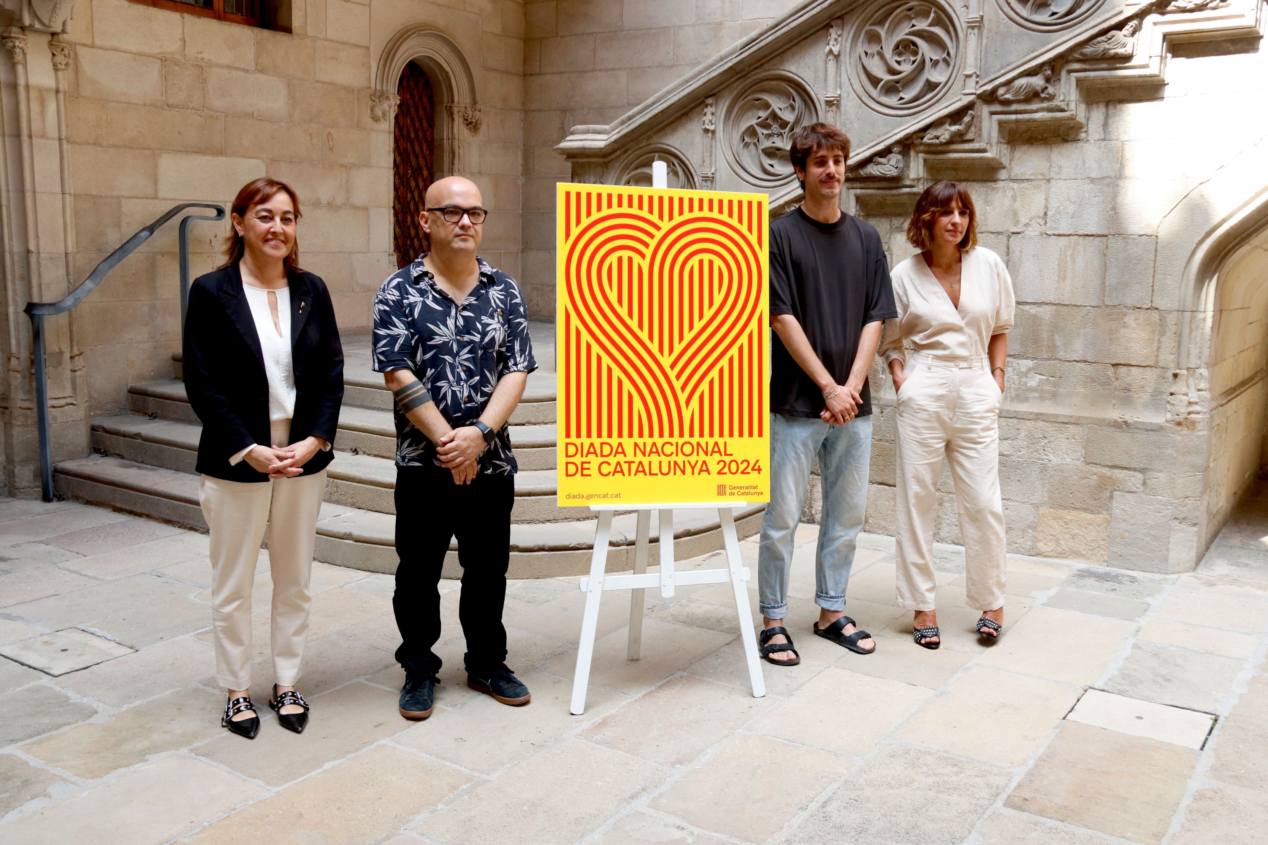 La portaveu i consellera del Govern, Sílvia Paneque, amb el cartell institucional de la Diada, acompanyada de diversos creadors de l'acte i la imatge