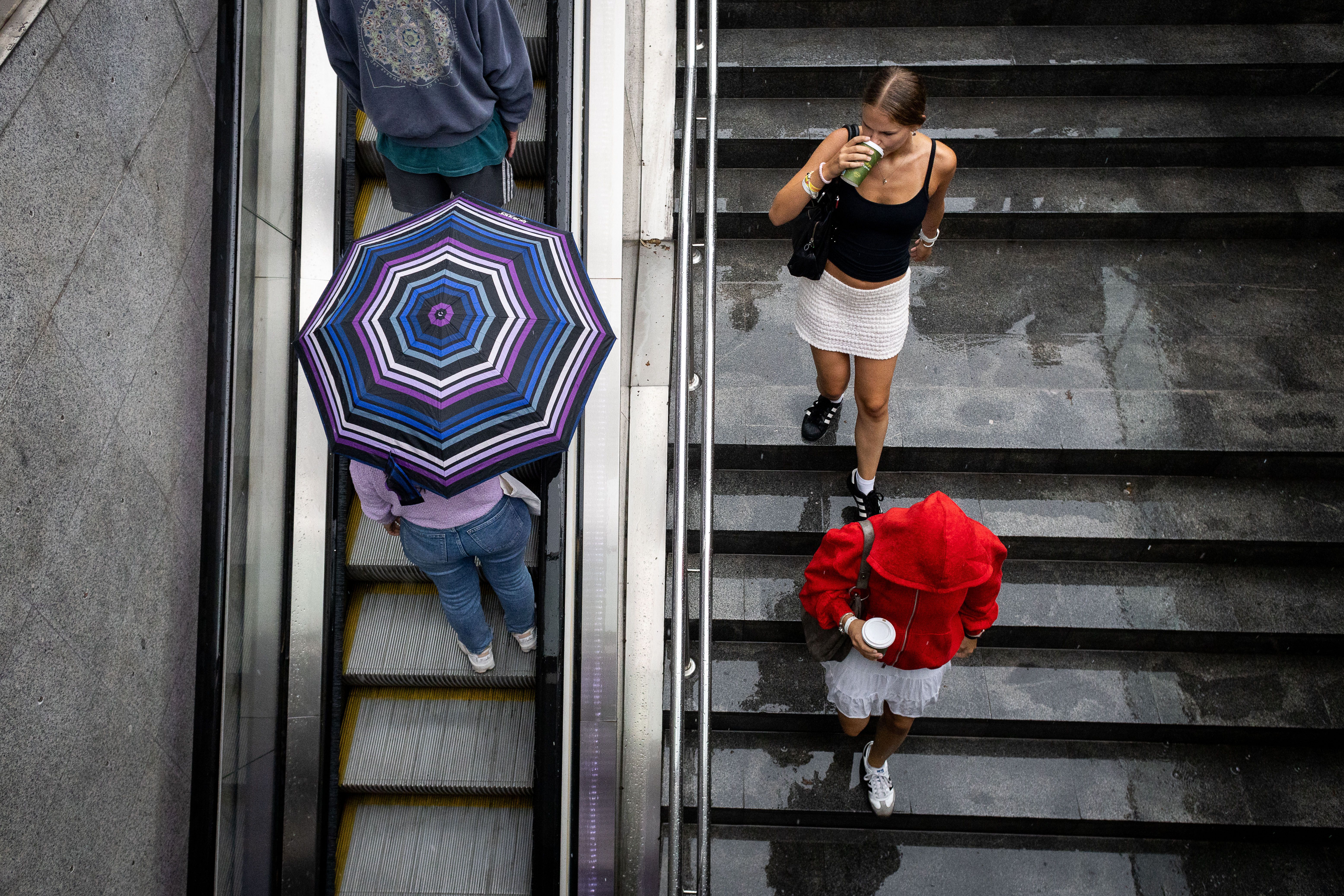 Diverses joves es refugien de la pluja, al centre de Barcelona