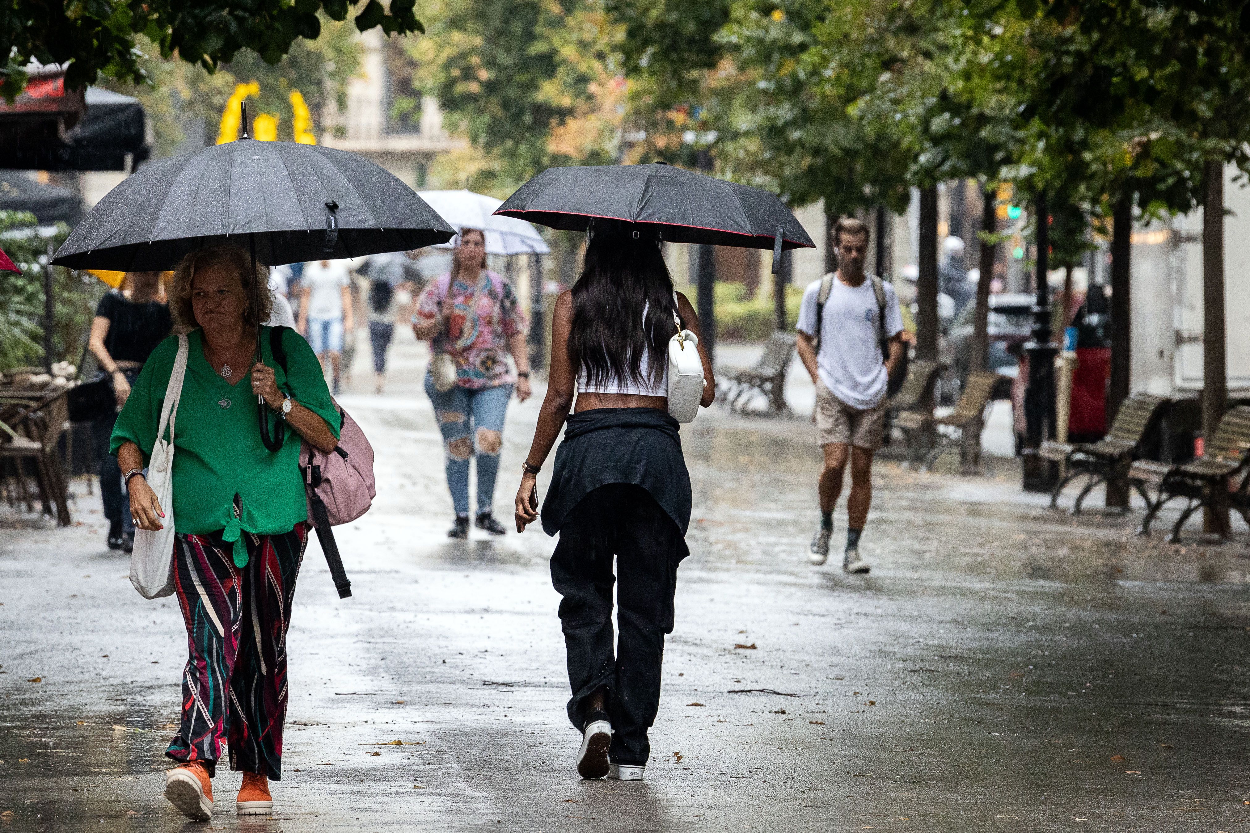 Diverses joves es refugien de la pluja, al centre de Barcelona