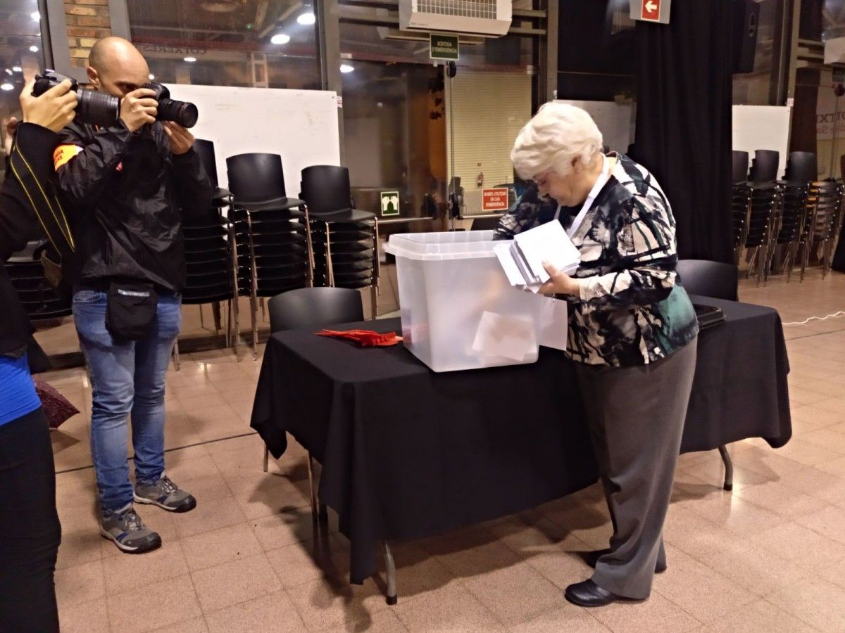 Una de les apoderades del referèndum col·locant les urnes a Sants