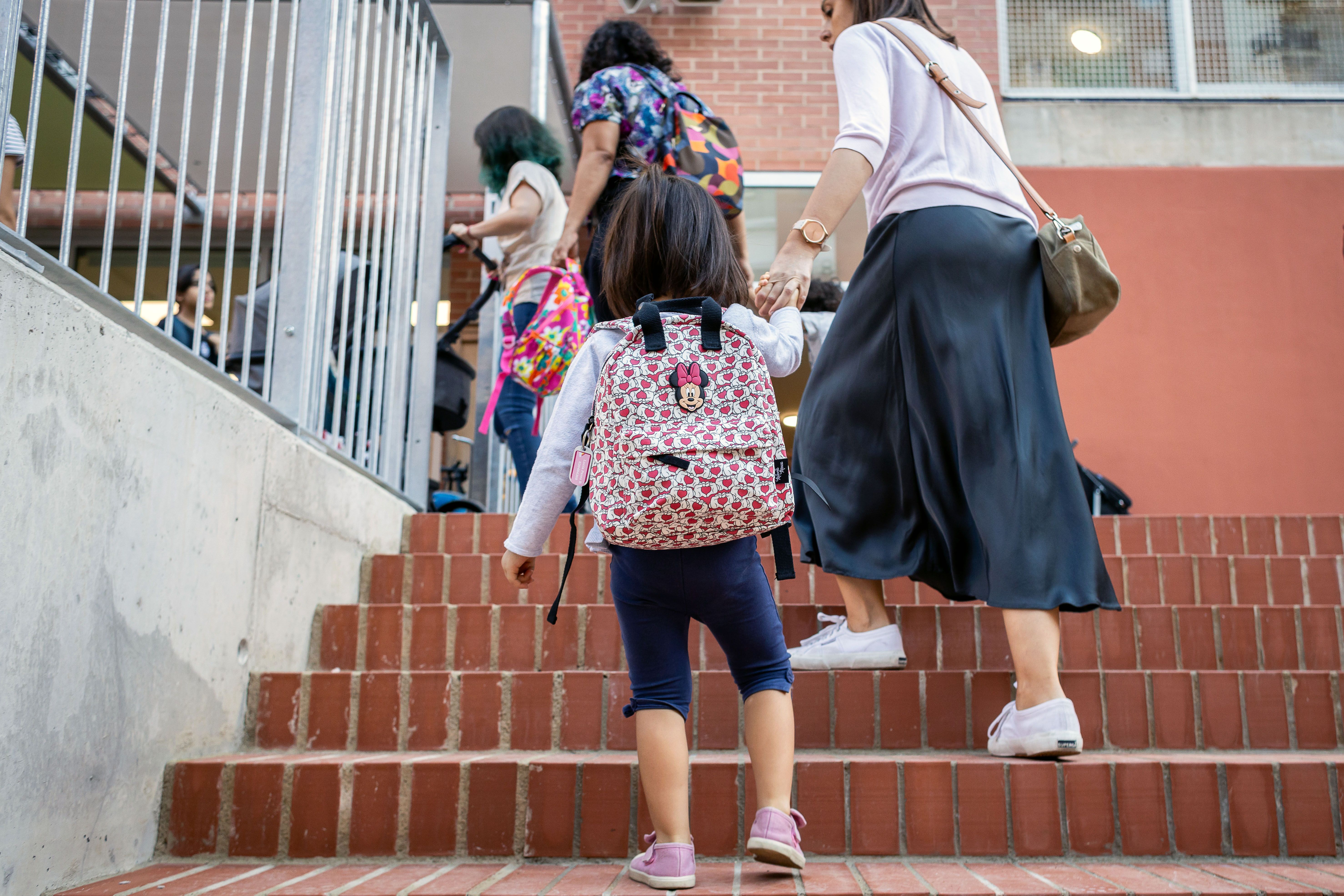 Imatge d'arxiu d'infants i adults entrant a una escola