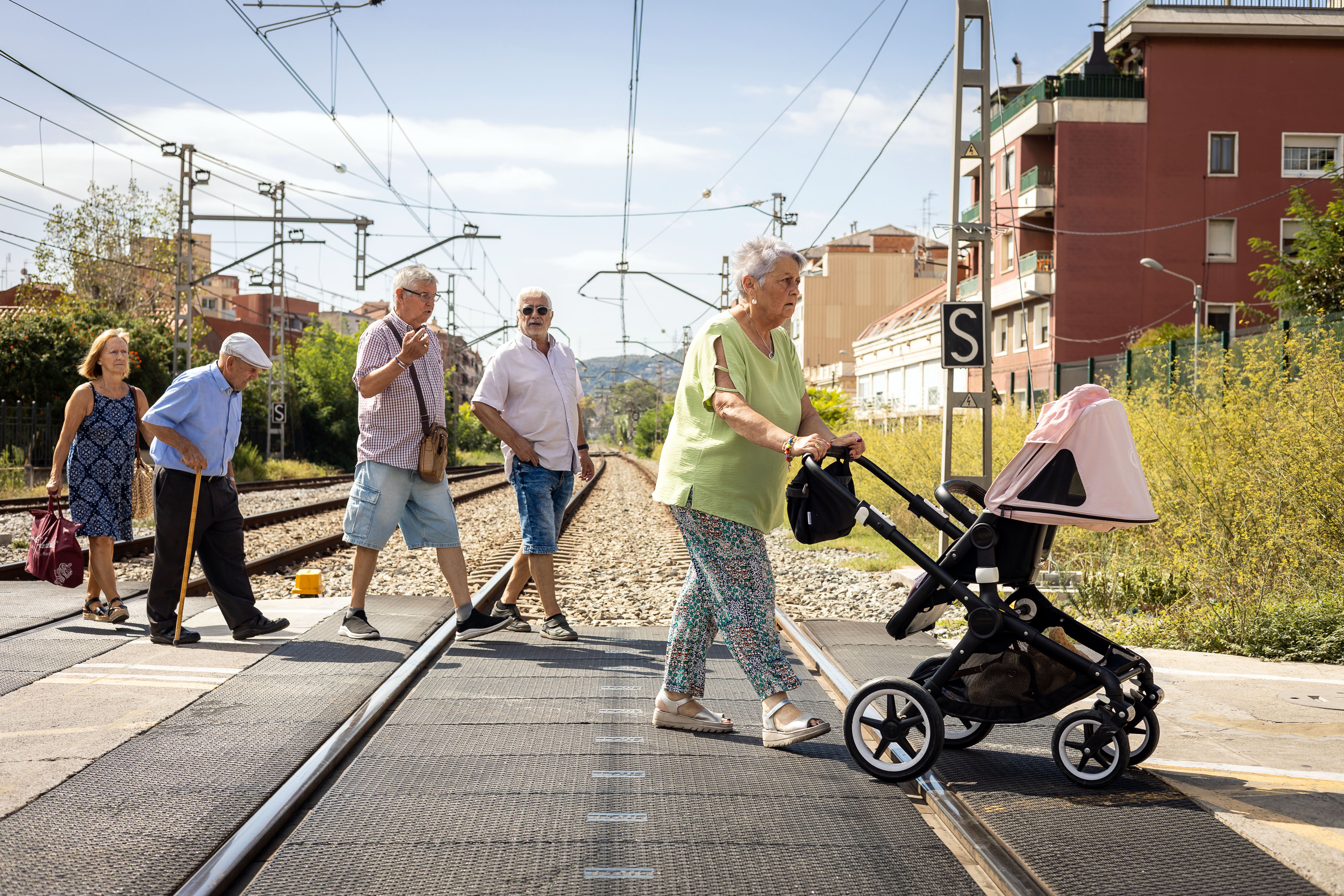 Veïns, molts gent gran, fent ús de les vies que travessen Montcada i Reixac