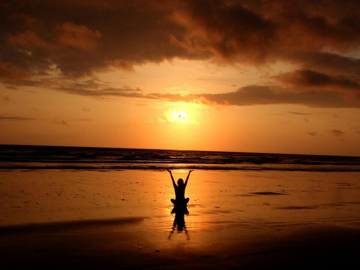 Persona meditant a la platja