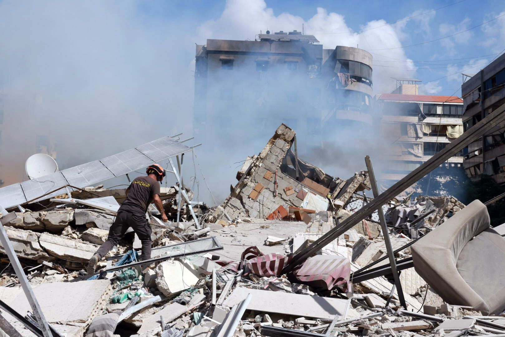 Un home camina sobre les ruïnes d'un edifici, després dels bombardejos israelians al districte d'Al-Hadath, als suburbis del sud de Beirut.