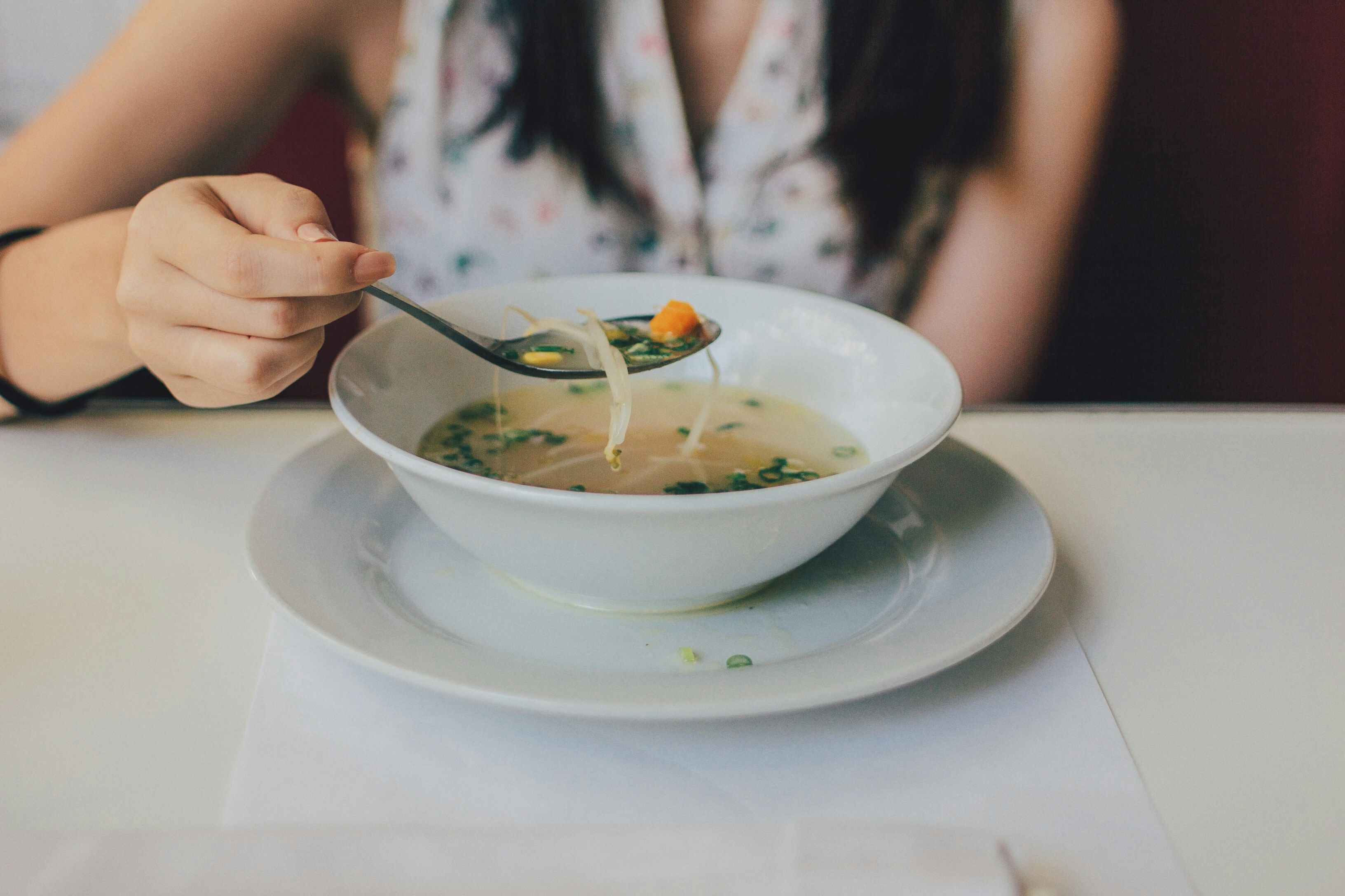 Una persona es menja un plat de sopa