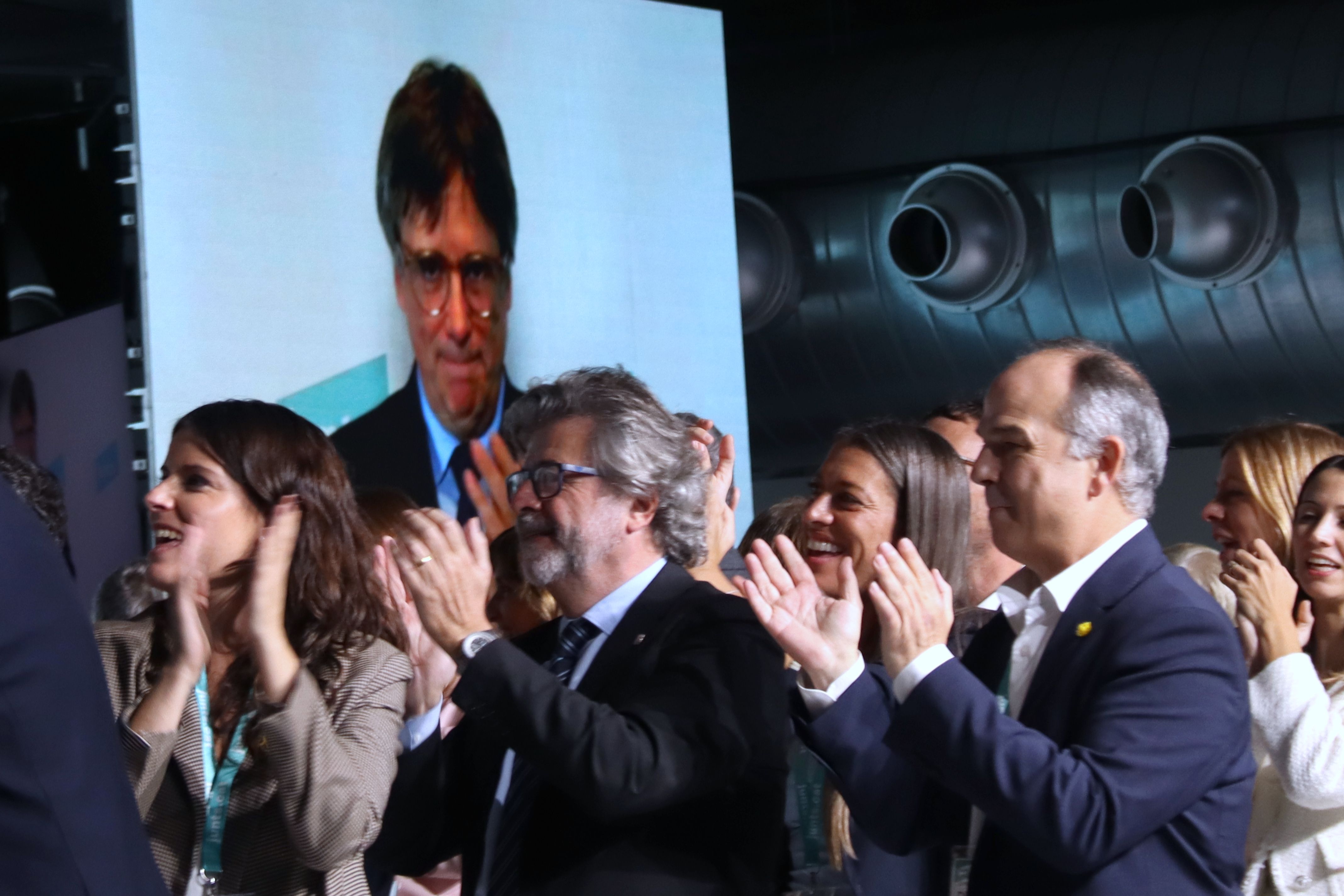 Carles Puigdemont, de fons, en el congrés de Junts.