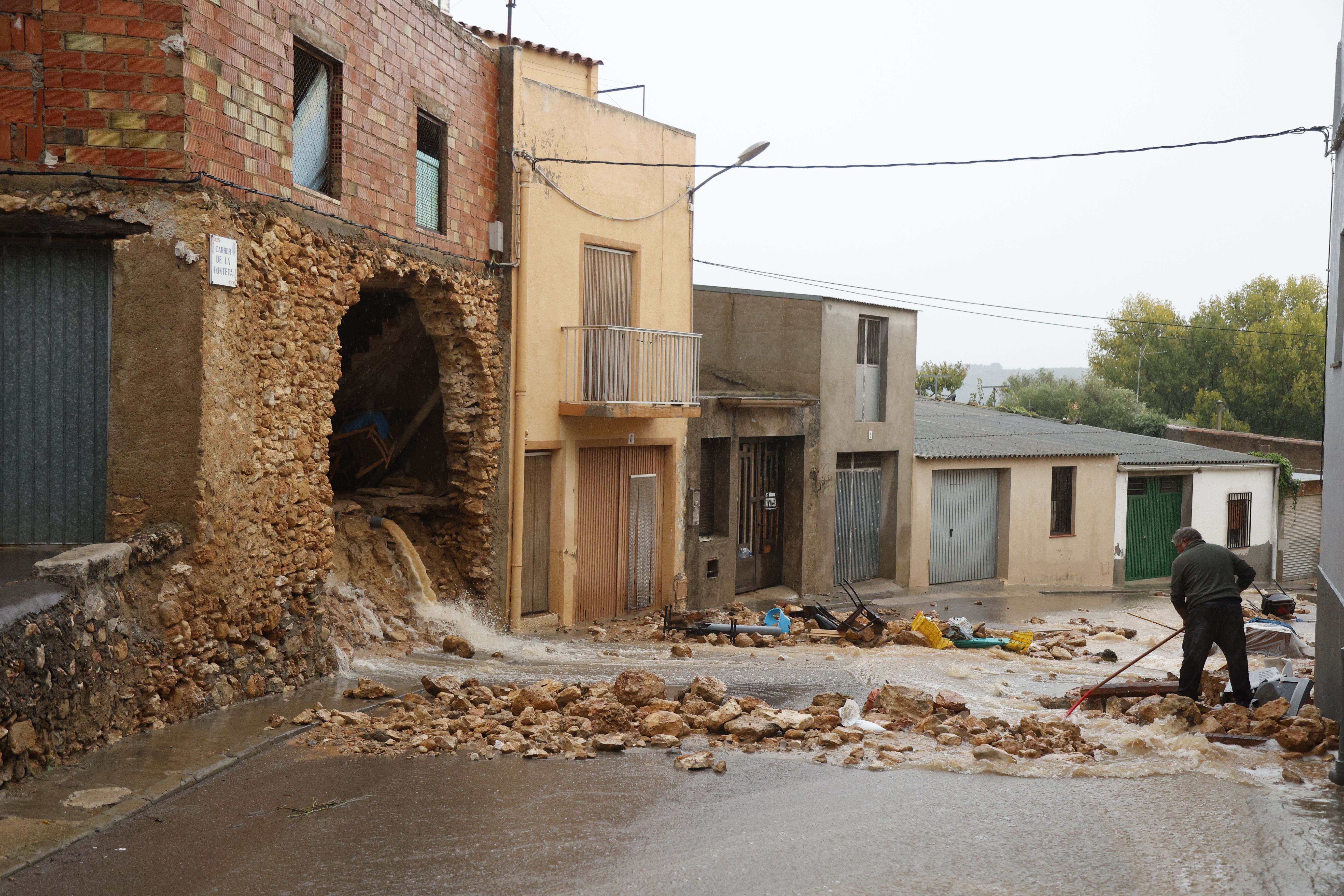 Un home neteja després que la DANA hagi afectat un habitatge a Torre d'en Domènec, Castelló