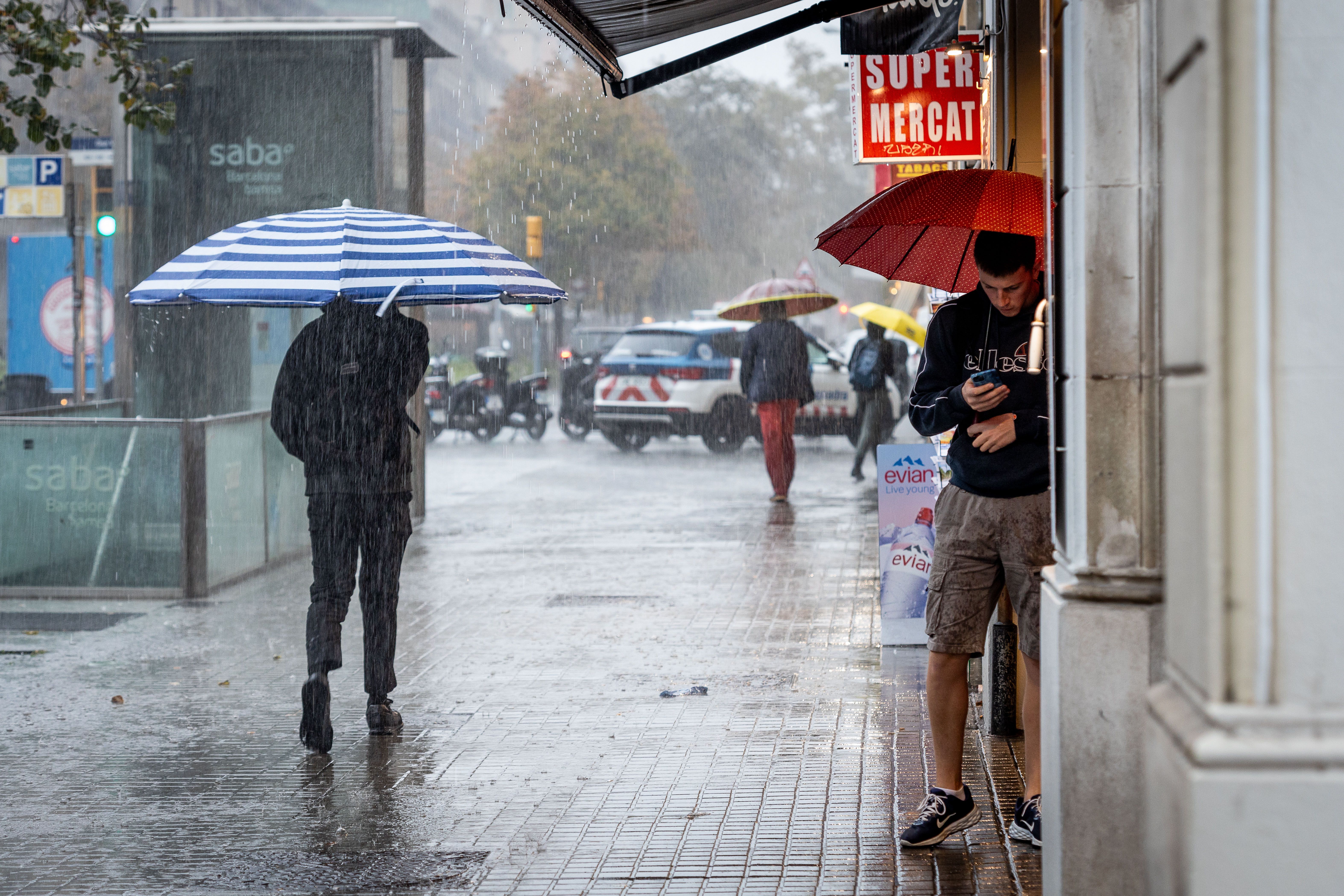 Diverses persones es refugien de la pluja a Barcelona