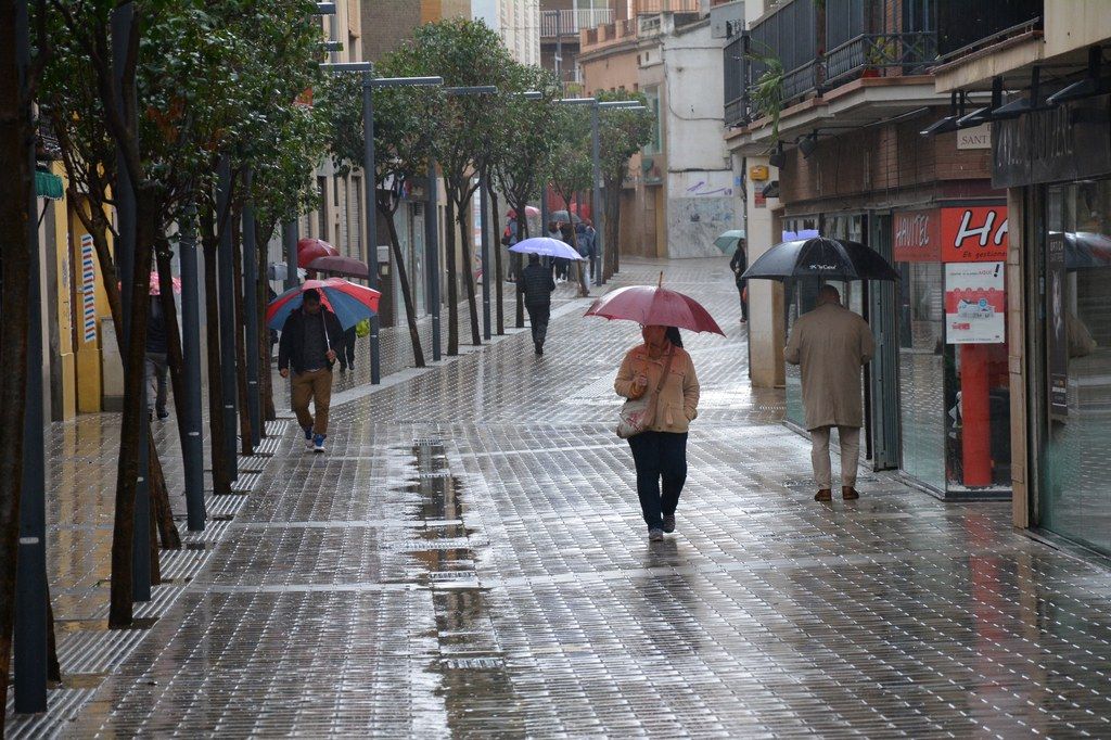 Gent caminant sota la pluja