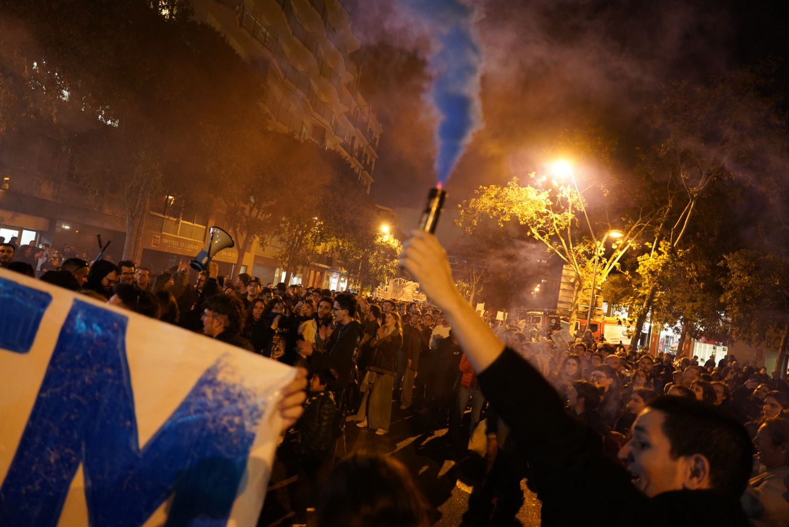 Un jove encén una bengala durant la protesta per la crisi habitacional d'aquest dissabte a Barcelona