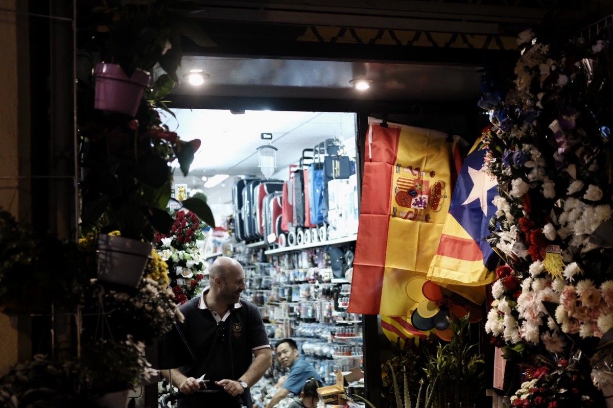 Una bandera espanyola i una bandera estelada en una botiga