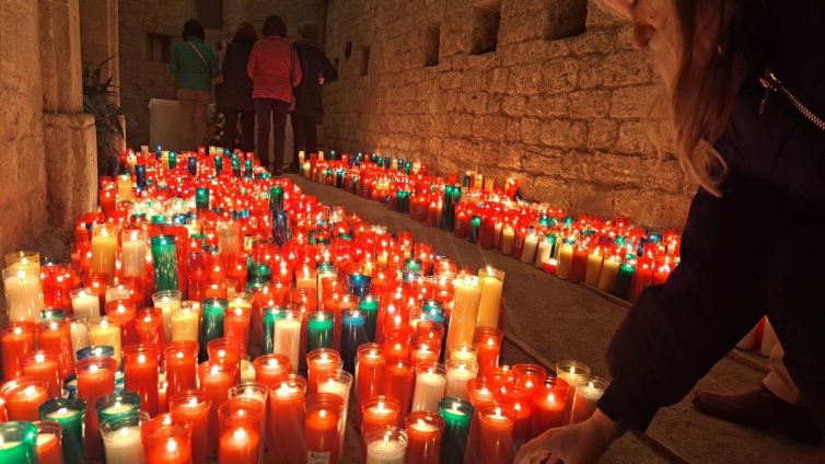 Una dona deixa un ciri a santa Llúcia, al claustre de la Seu. Foto: Pere Fontanals