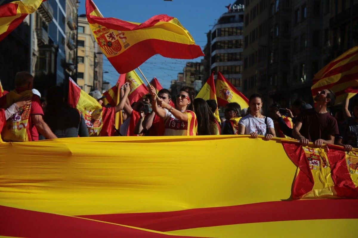 Una manifestant fa onejar una bandera espanyola a la capçalera 