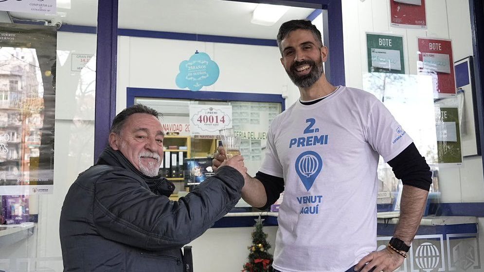 Dani Zapata Frías, venedor de loteria, celebra amb un veí, a Barcelona