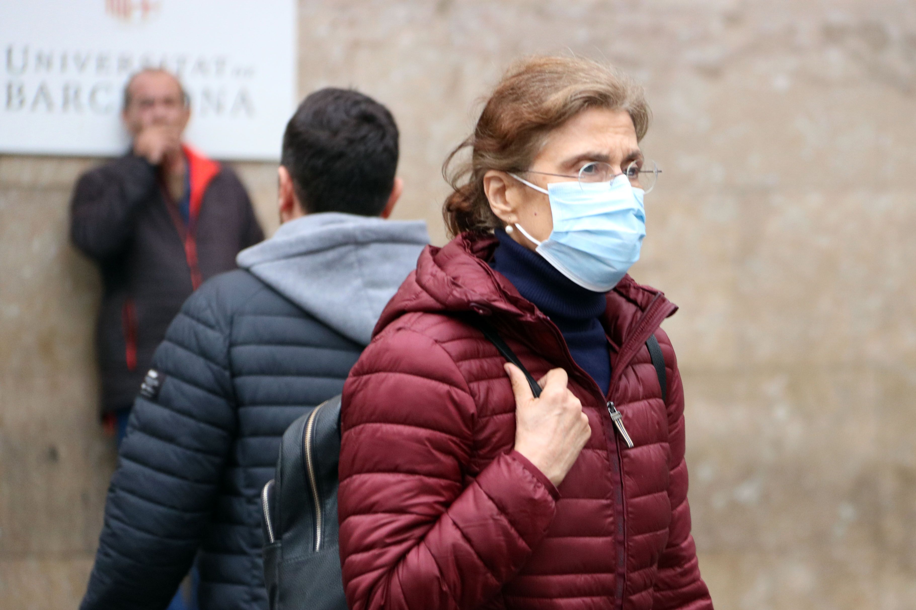 Una dona davant l'entrada principal de l'hospital Clínic