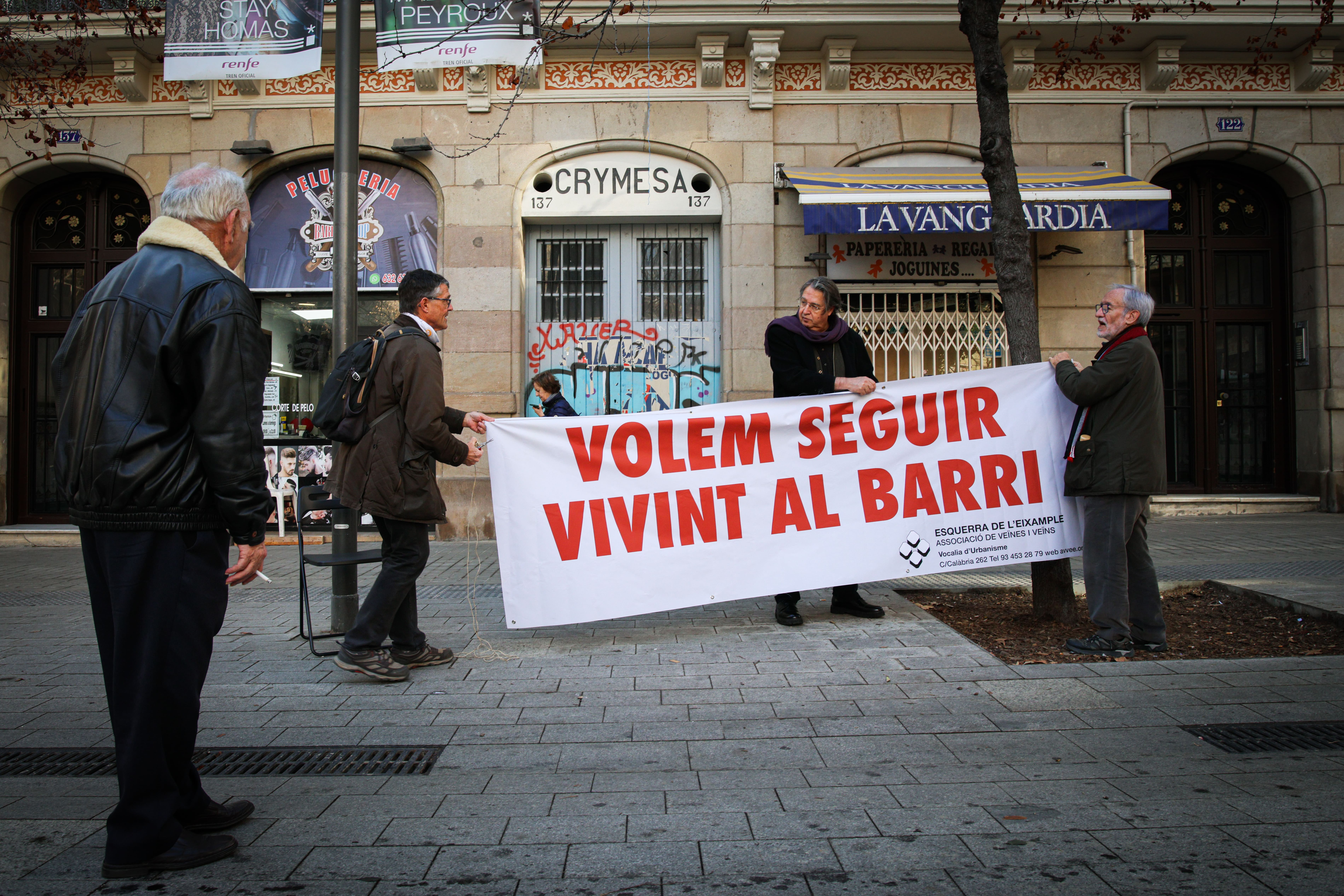 Veïns penjant una pancarta contra els desnonaments a la Casa Orsola