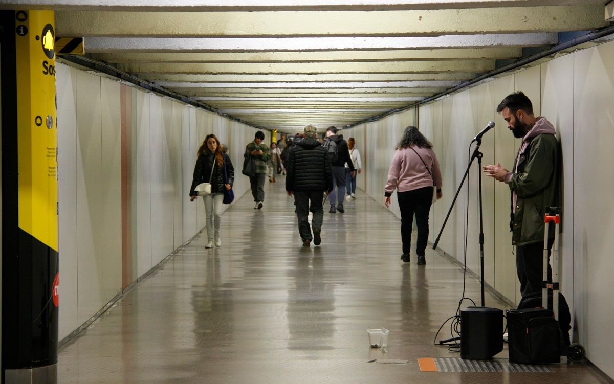 Una persona canta al passadís del transbordament més llarg del metro de Barcelona