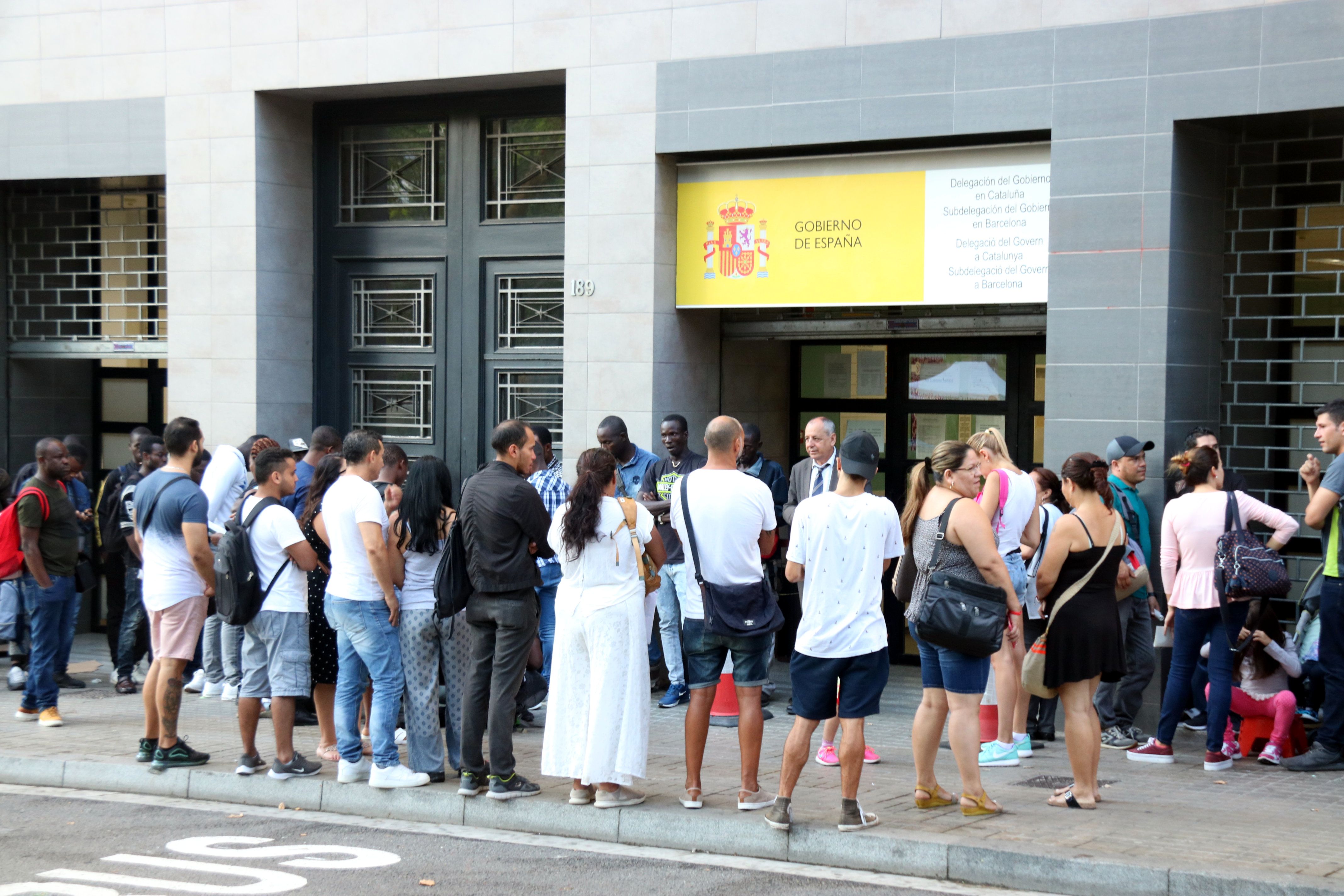 Cua de persones migrades en una oficina de l'administració.