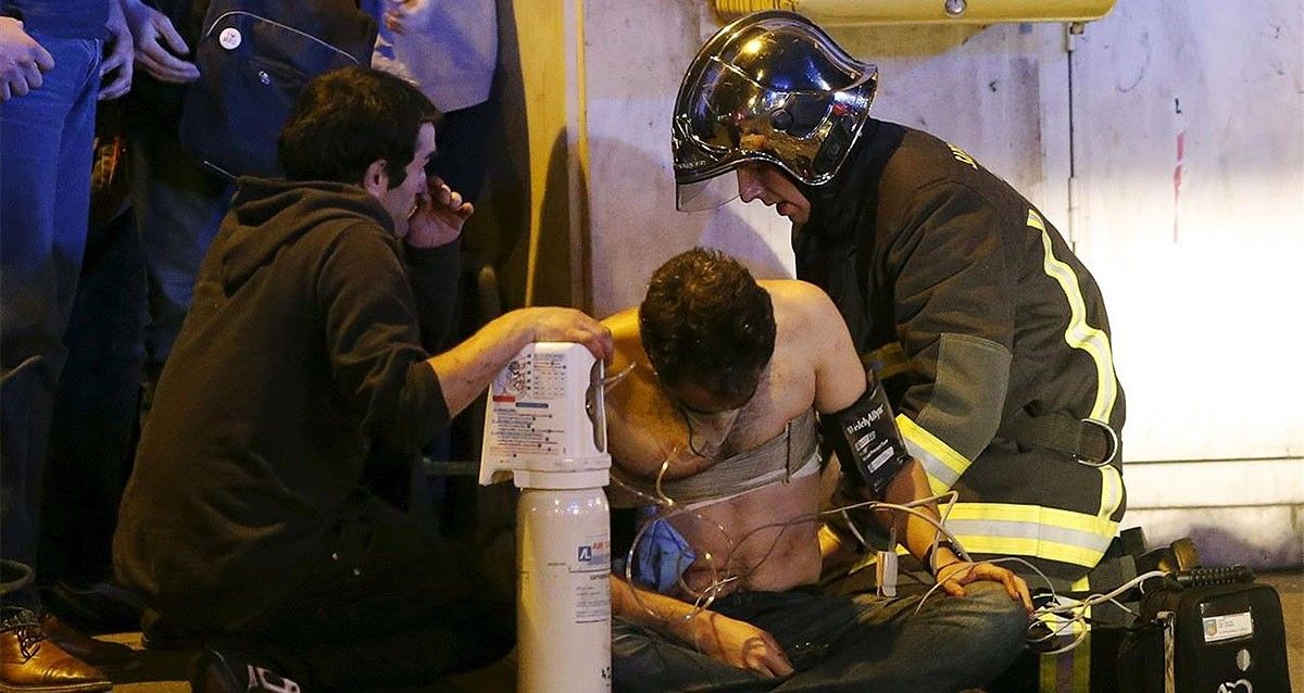 Els serveis d'emergència atenent un dels ferits en els atacs a París