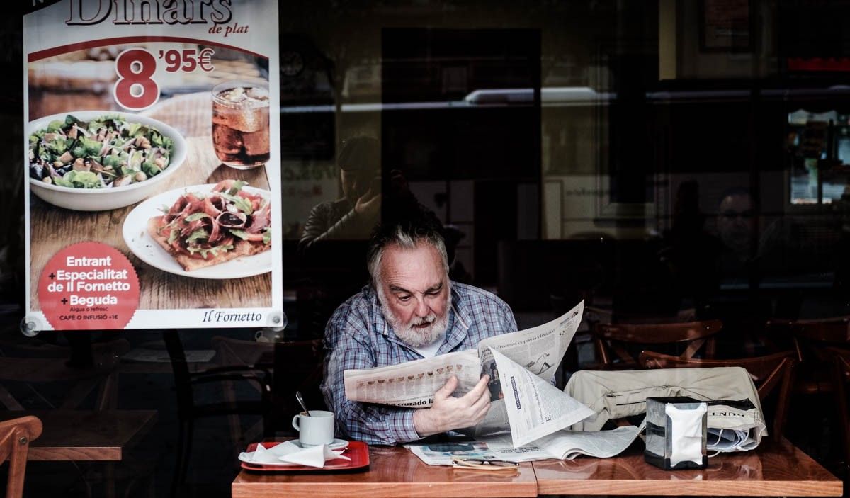 Un home llegint el diari en una cafeteria