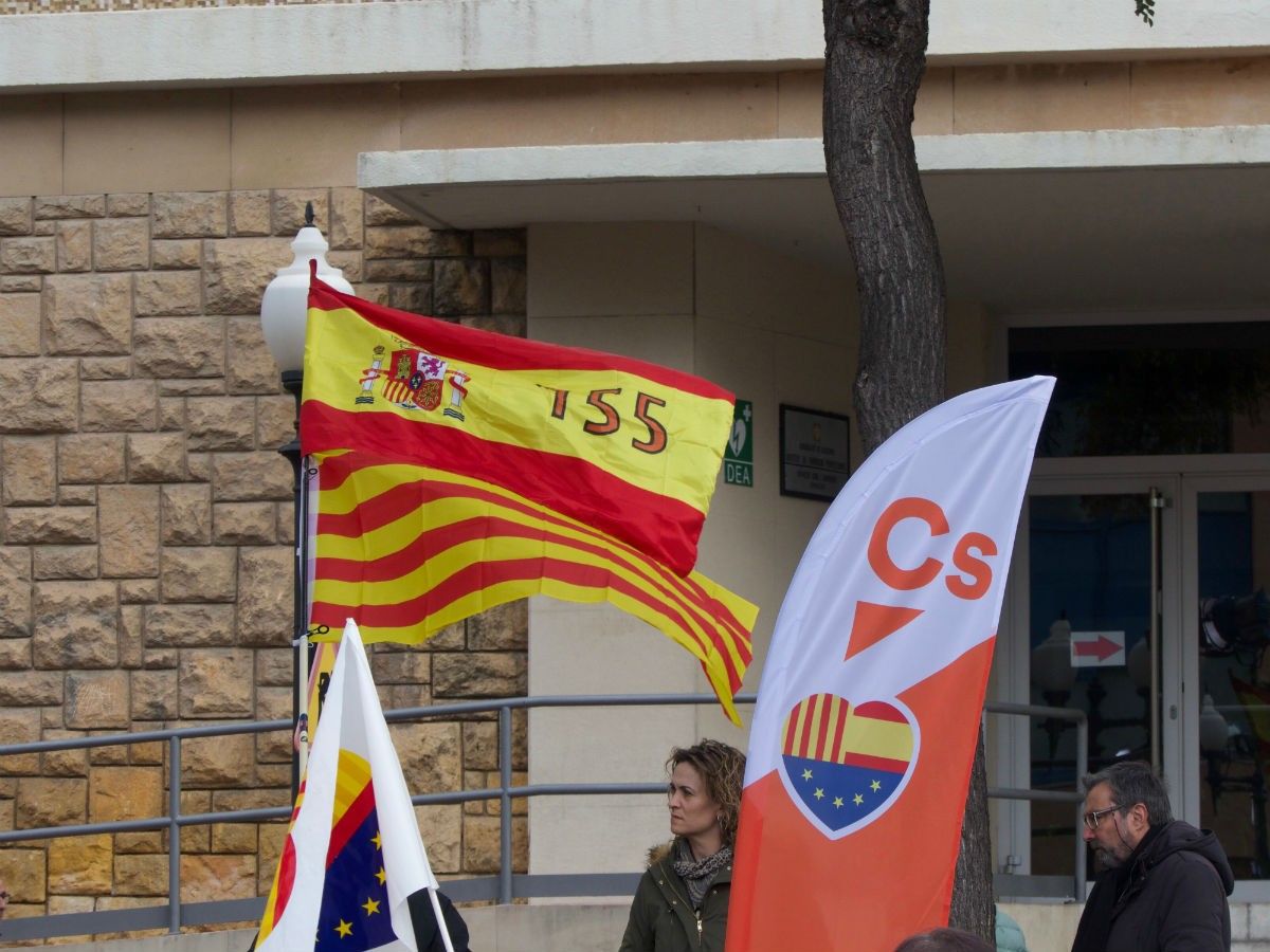 Un assistent oneja una bandera espanyola amb el 155 en el míting tarragoní de Cs.