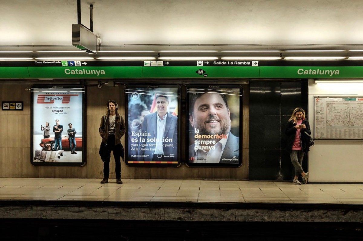 Viatgers del metro al costat de cartells electorals