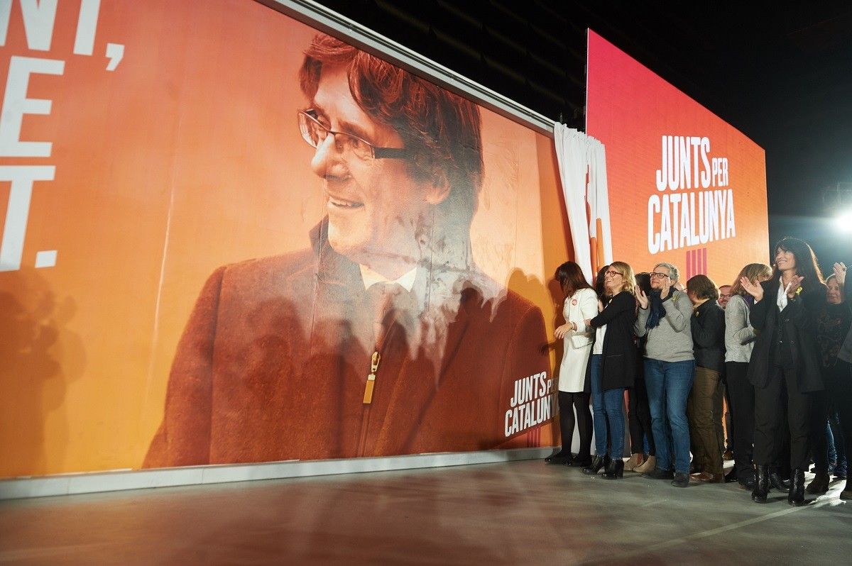 Els integrants de Junts per Catalunya ensenyen el cartell electoral de Puigdemont