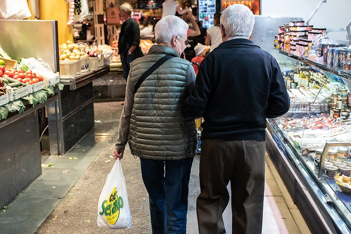 Una parella de jubilats comprant al mercat