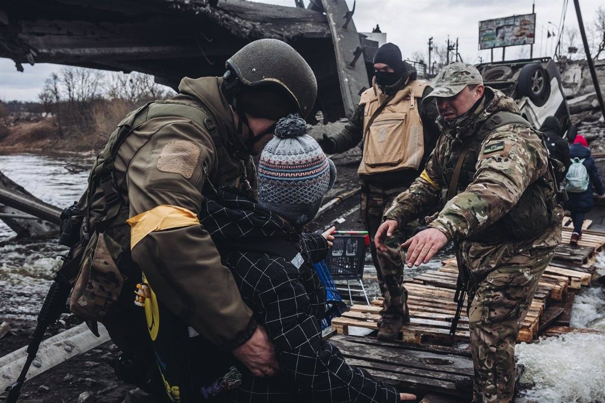 Els soldats ajuden un nen ucraïnès a creuar el riu