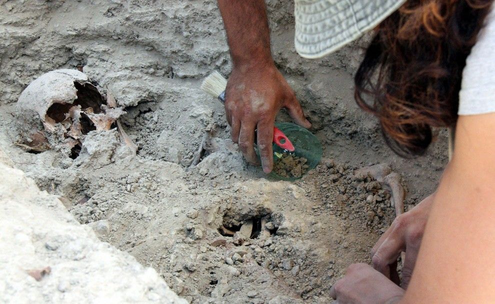 Arqueòlegs treballant en una fossa comuna a Gurb.