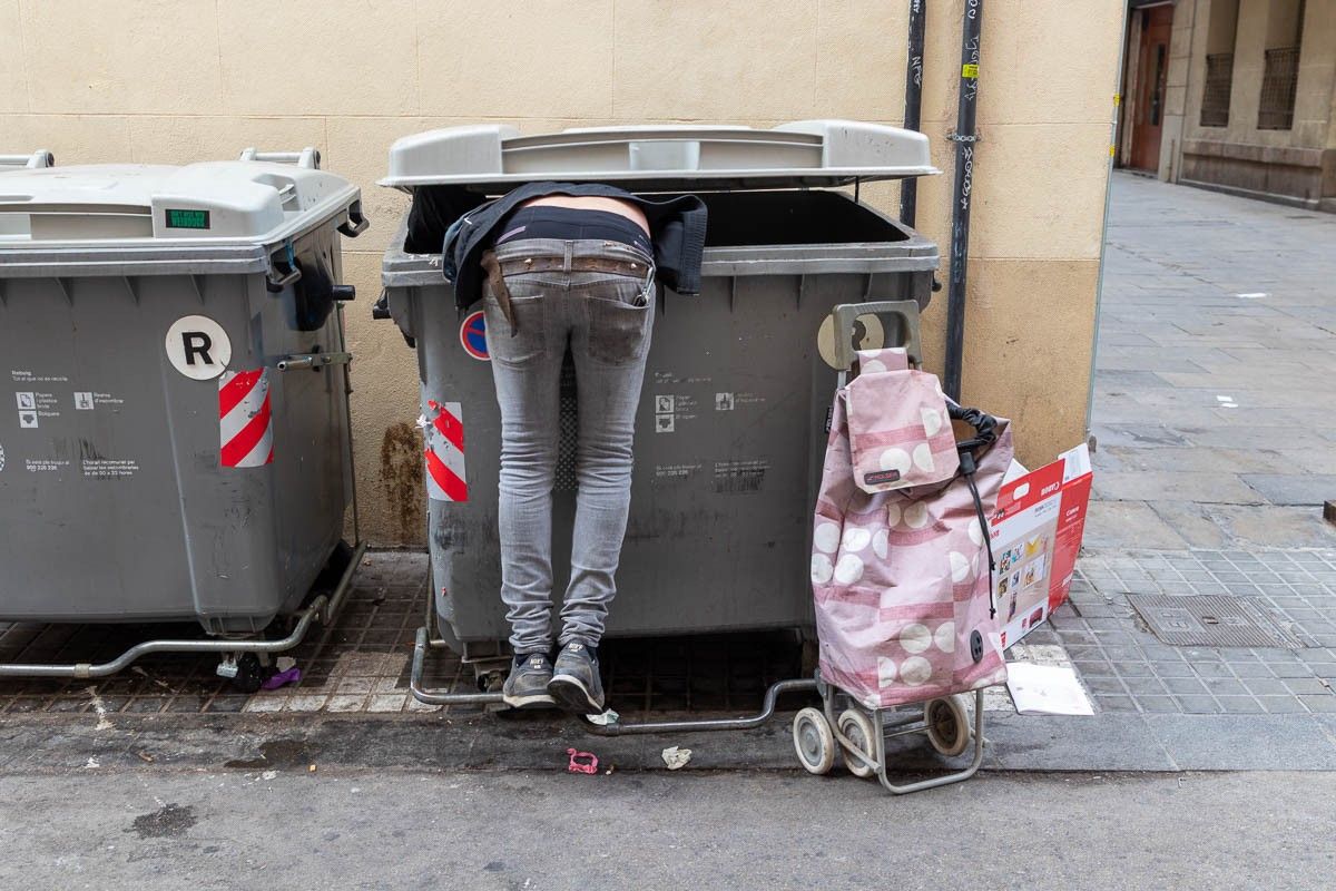 Un home, buscant en un l'escombraria, a Barcelona.
